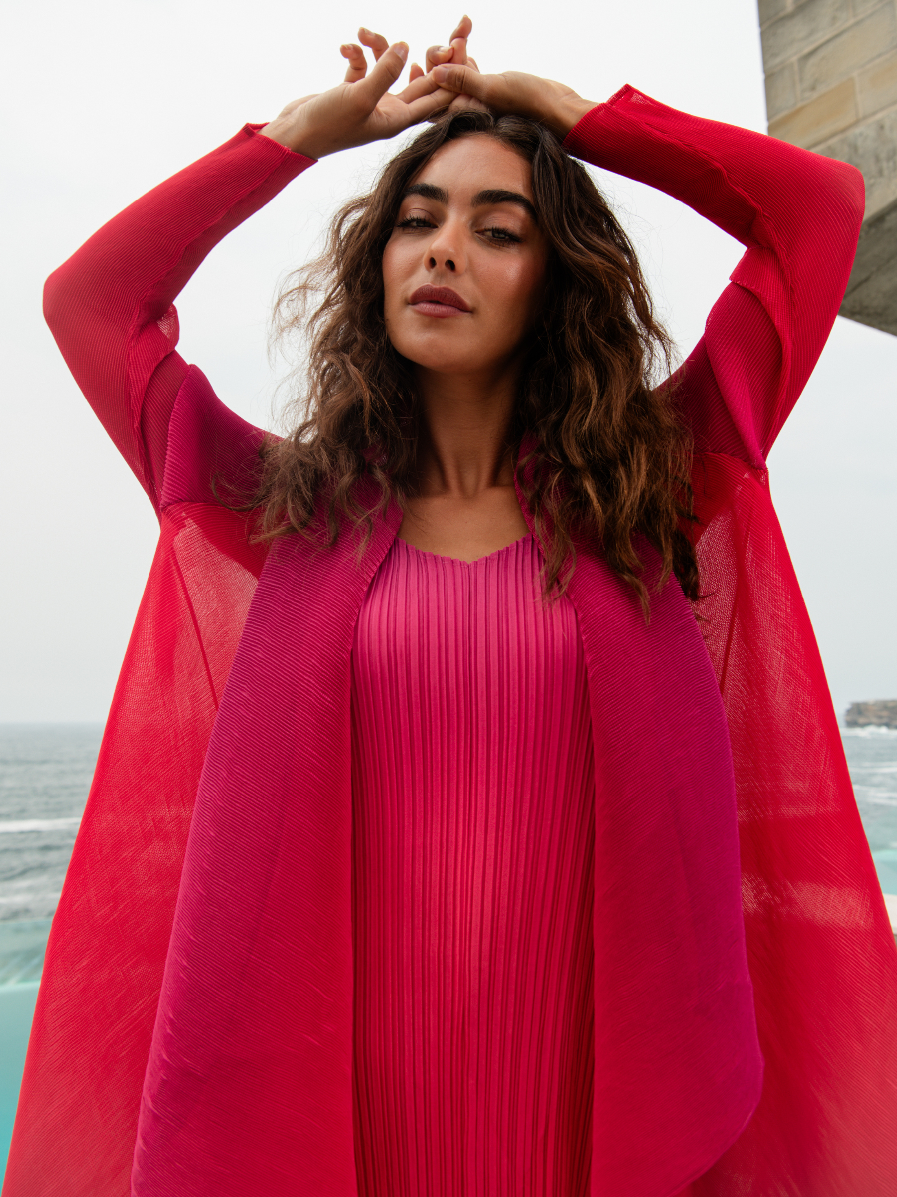 Alquema Festival Sunrise Dress & Coat hand-pleated dress and coat set with pink and coral ombré, flowing silhouette and draped sleeves.