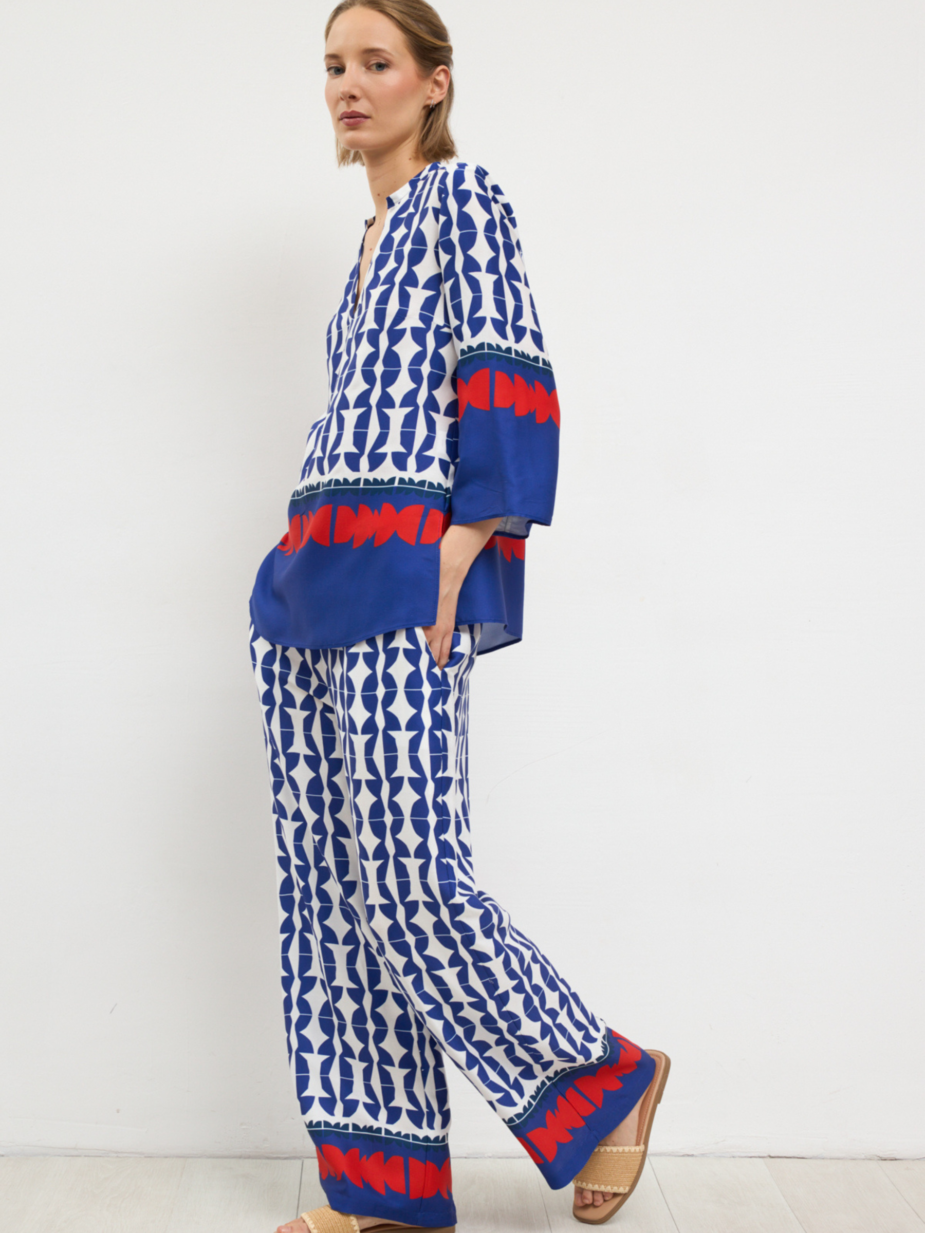 Bariloche Filigrana / Arcadia Set women’s printed co-ord with V-neck tunic top and wide-leg trousers in blue and white geometric design.