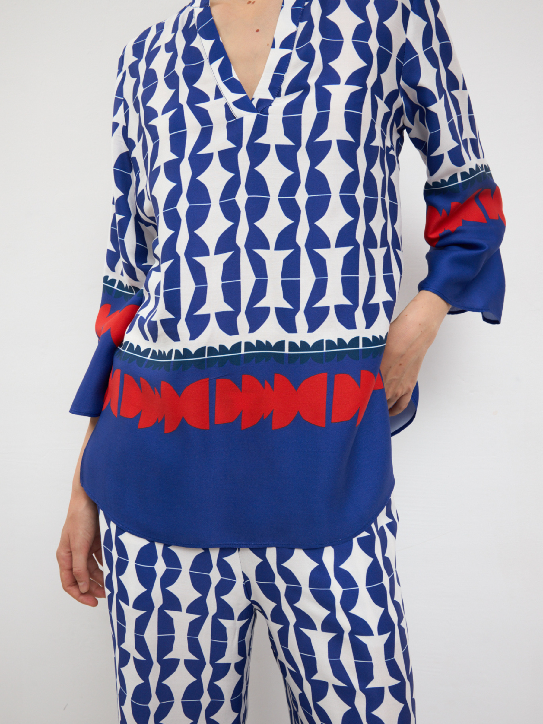Bariloche Filigrana / Arcadia Set women’s printed co-ord with V-neck tunic top and wide-leg trousers in blue and white geometric design.