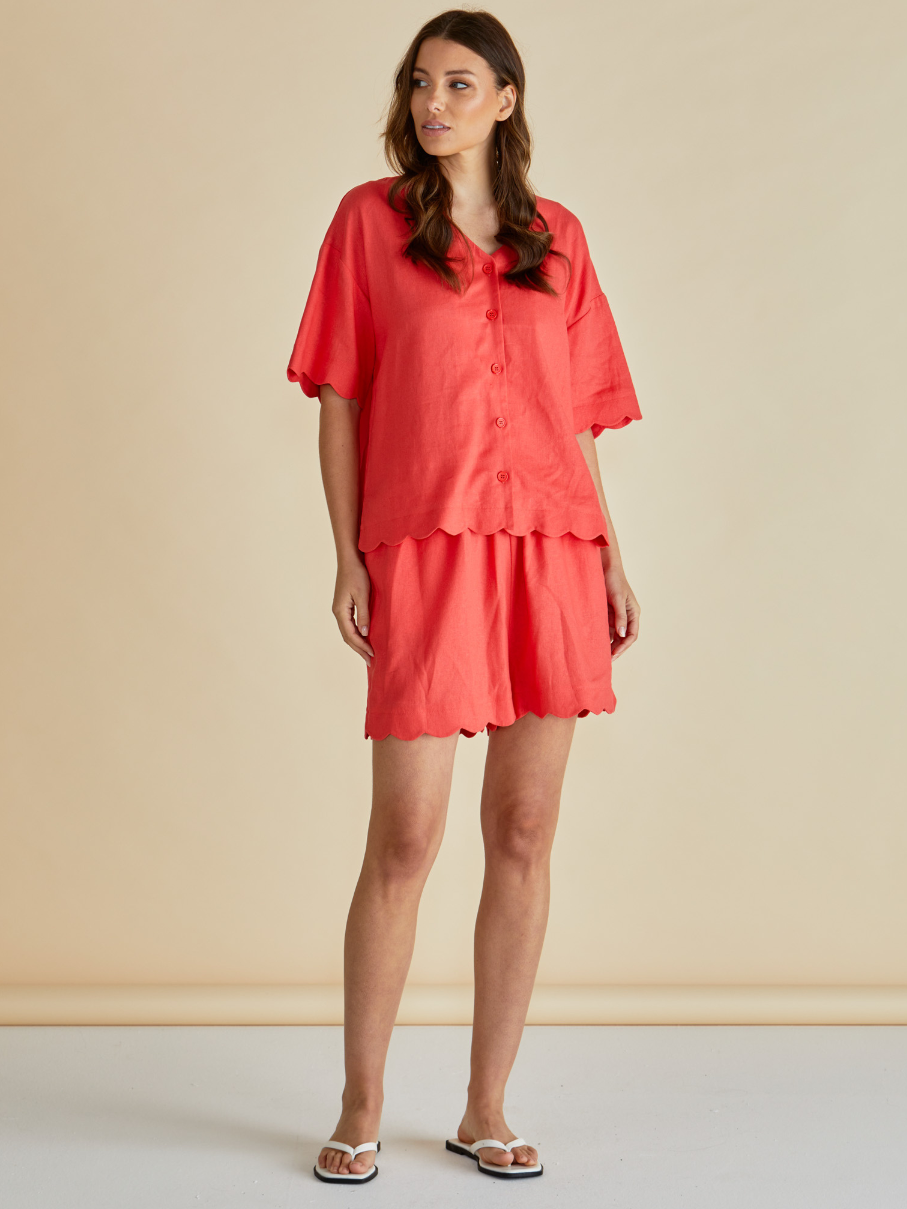 Betty Scarlett Shirt with V neckline, button-through front, short sleeves and scalloped hem.