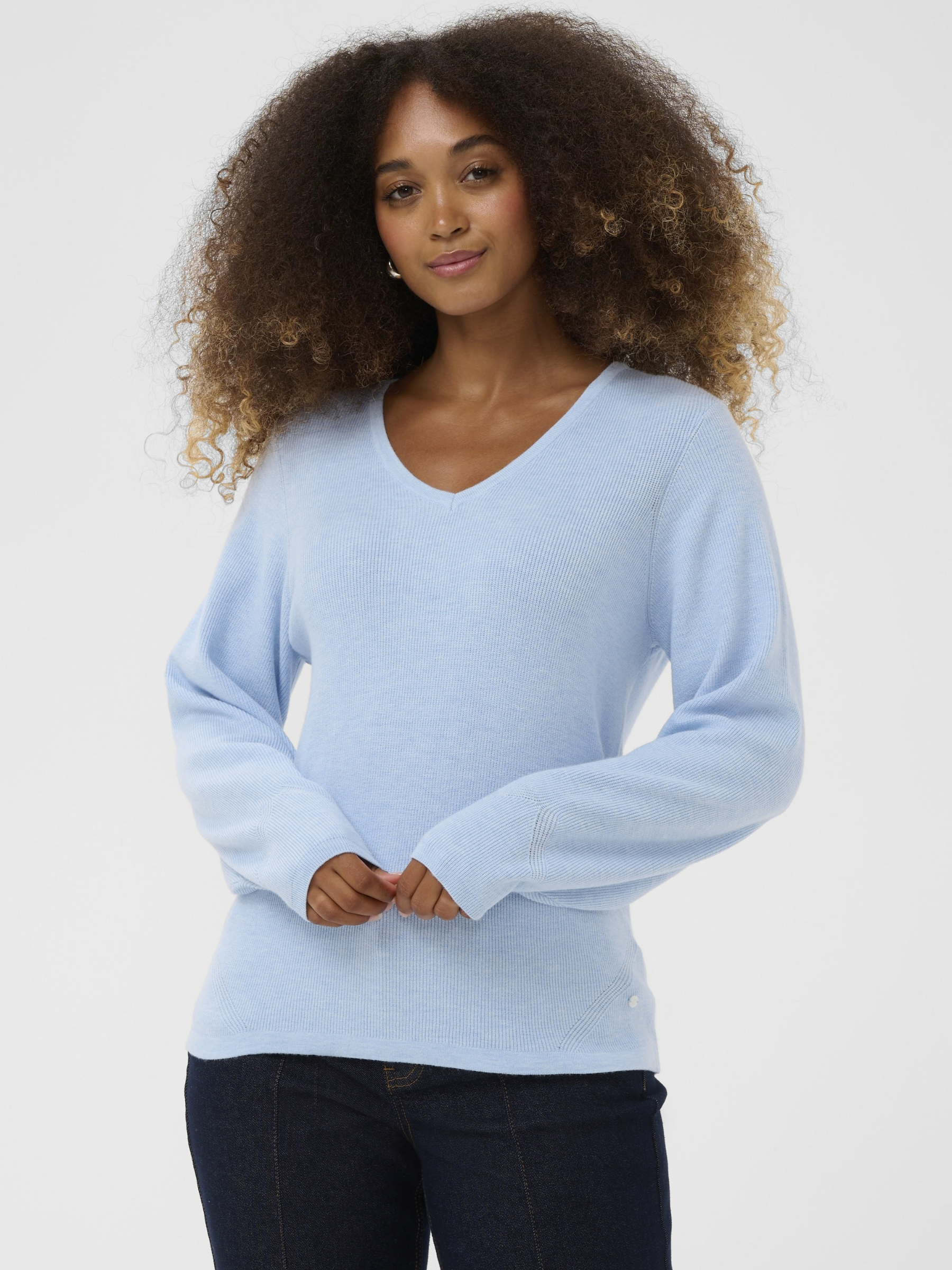Cream Dela Knit Blouse women’s relaxed fit long-sleeve knit top with a soft drape and hip-length cut, styled casually.