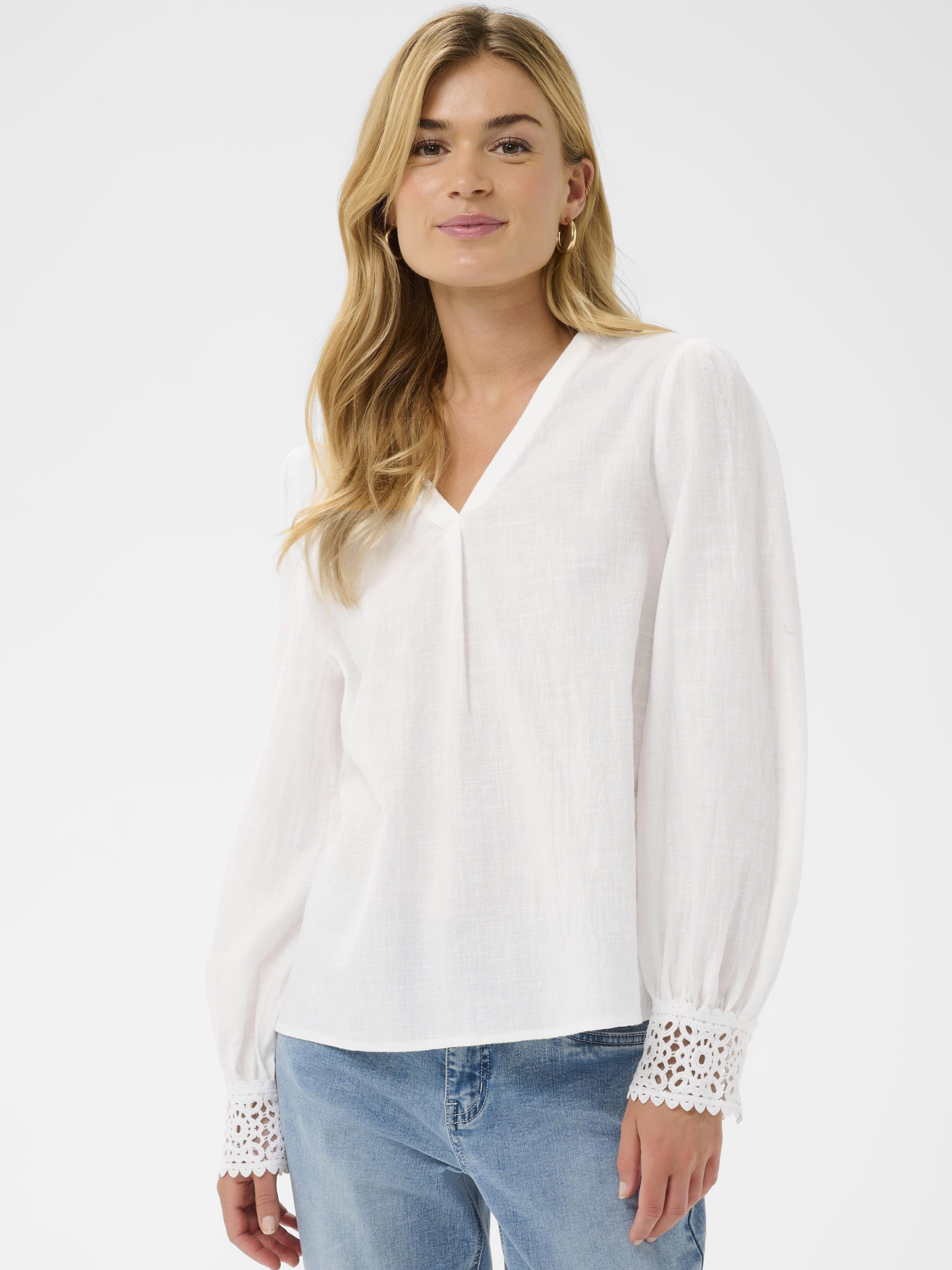 Cream Delia white V-neck blouse with long sleeves and lace cuff detailing in lightweight cotton.