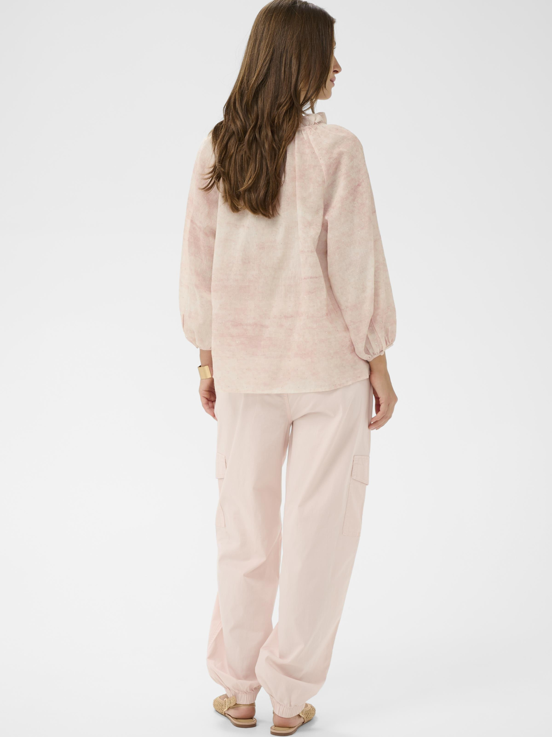 Cream Gitta blush tie-neck blouse with long sleeves and soft gathered neckline in lightweight textured fabric.