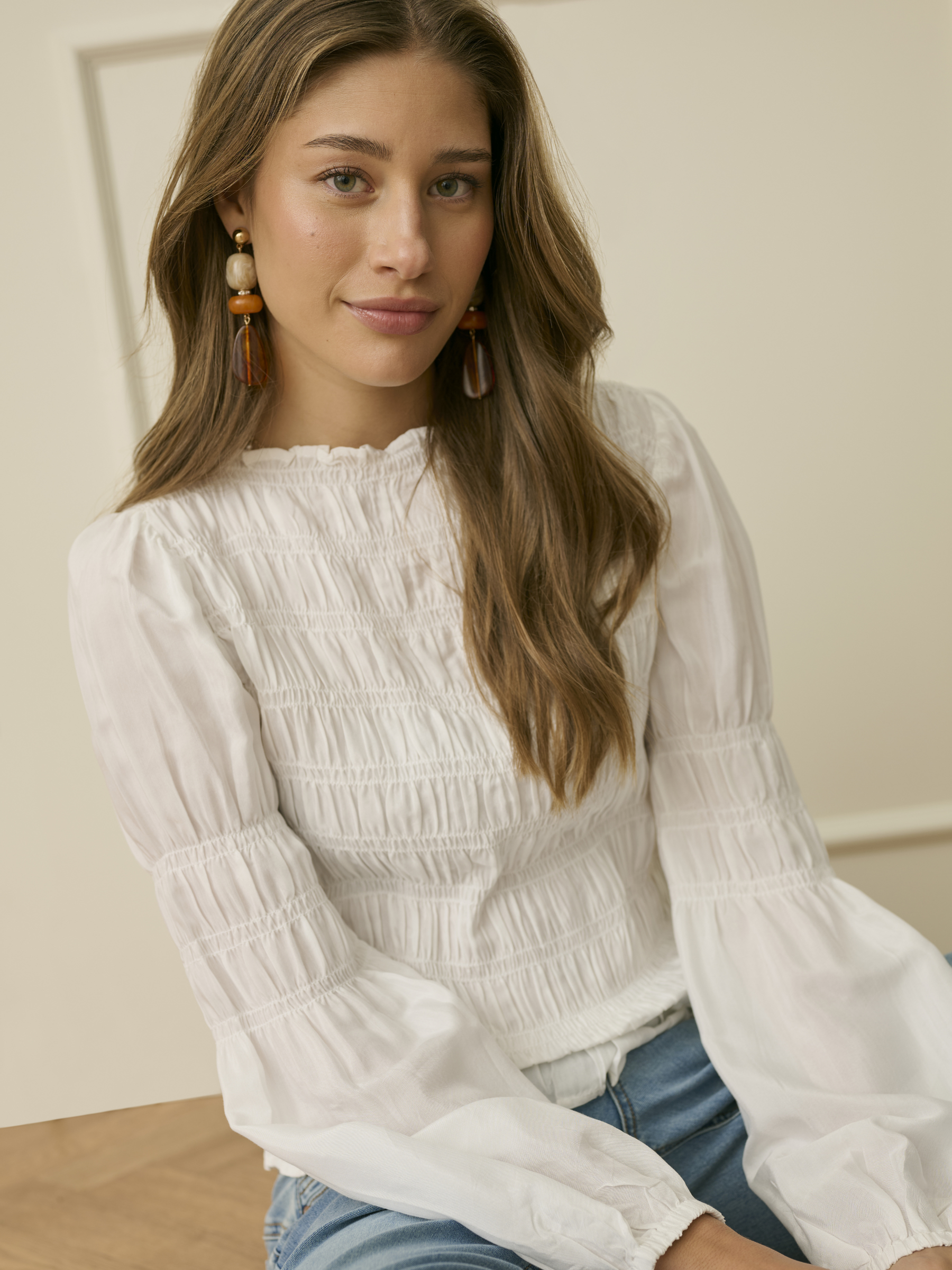 Cream Henva Blouse with shirred texture design and frill hem.