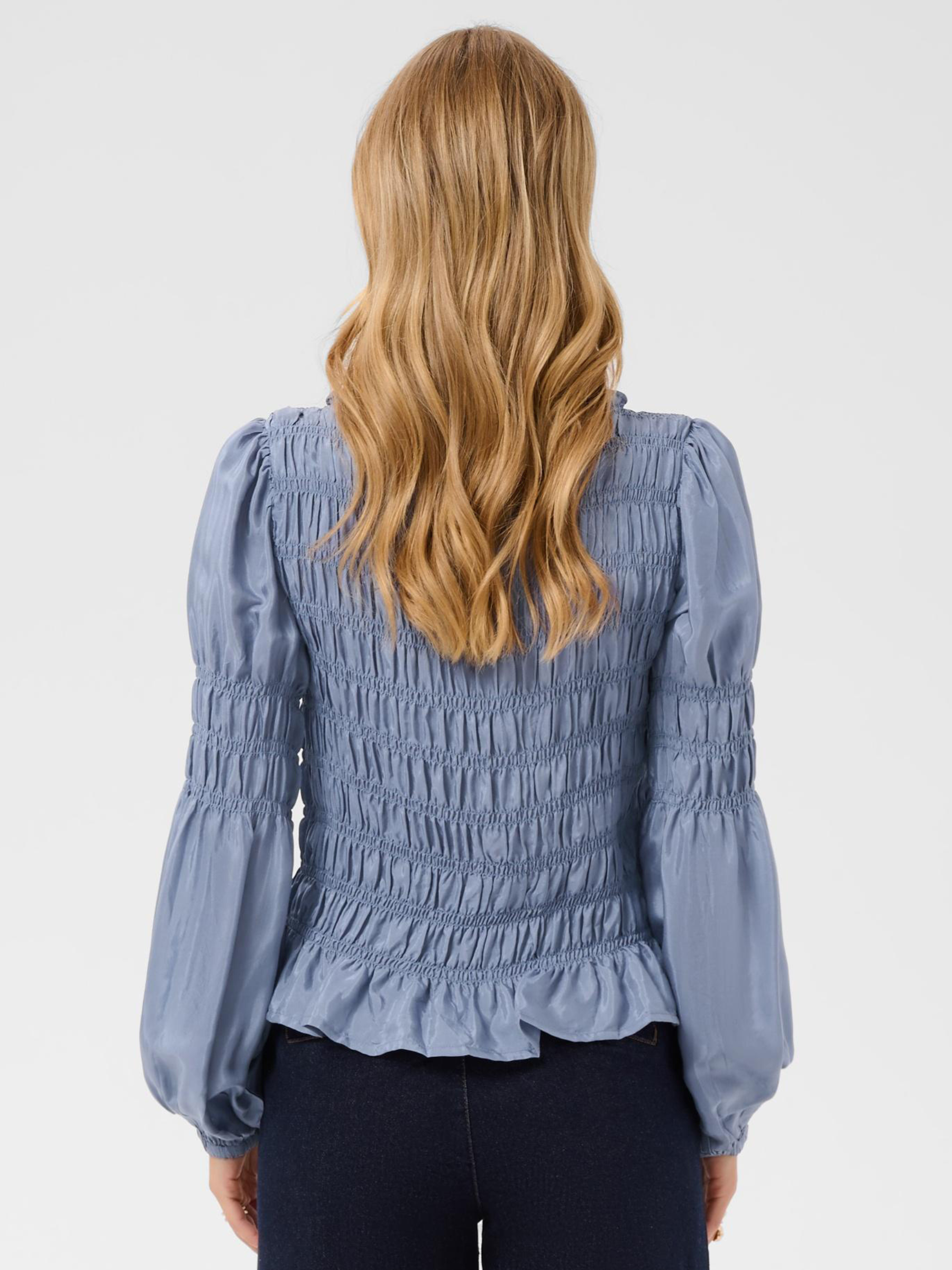 Cream Henva Blouse with shirred texture design and frill hem.