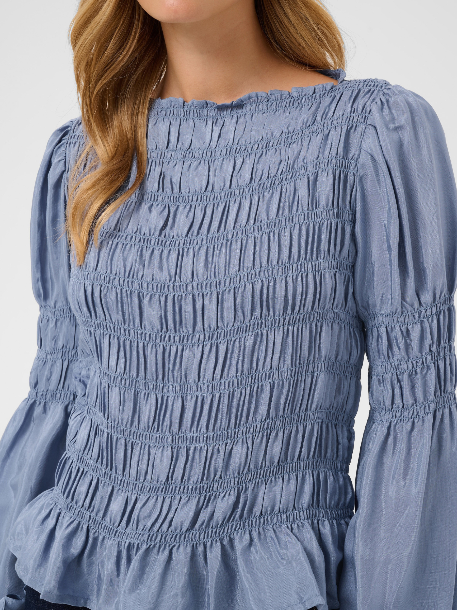 Cream Henva Blouse with shirred texture design and frill hem.