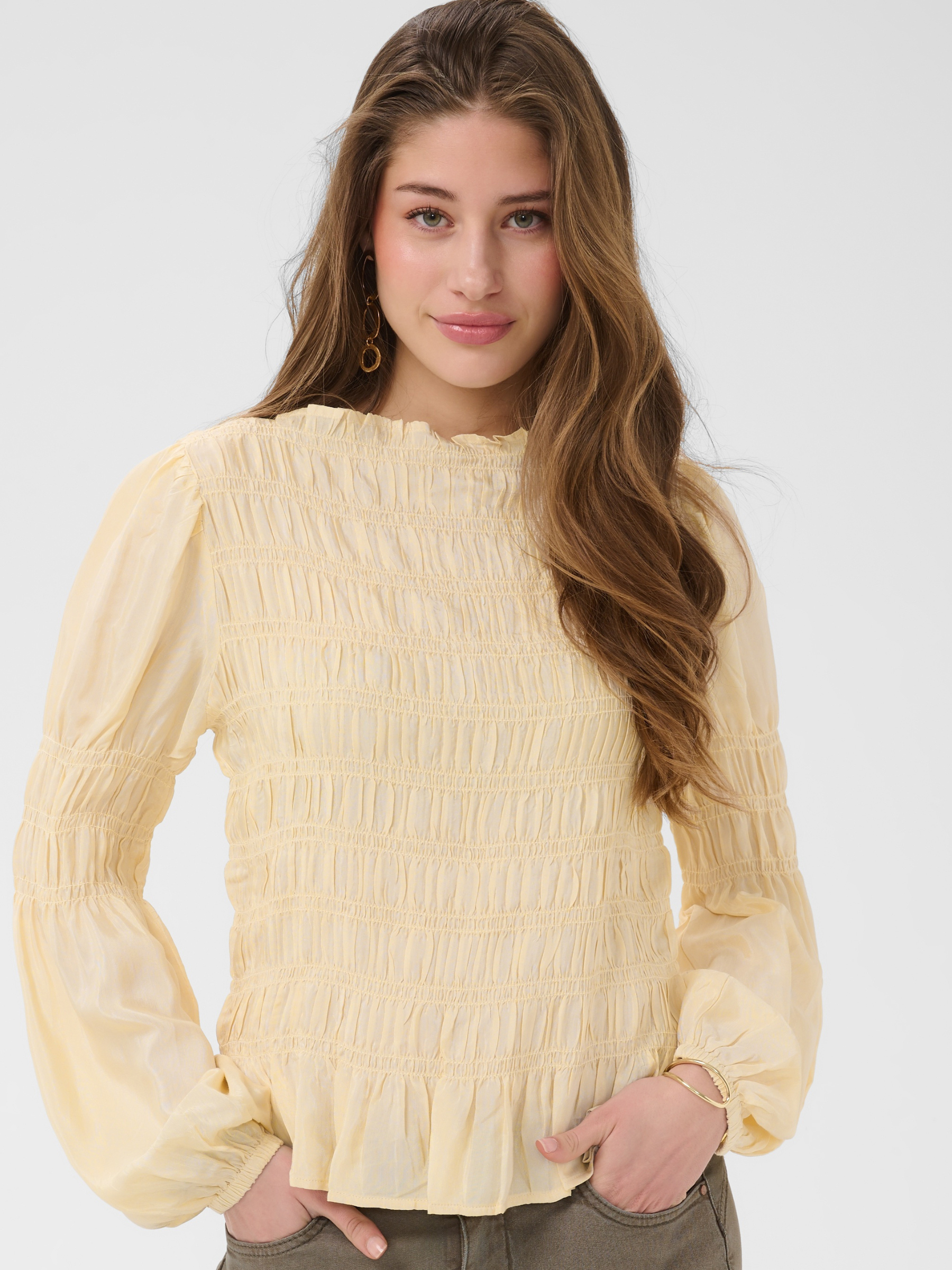 Cream Henva Blouse with shirred texture design and frill hem.