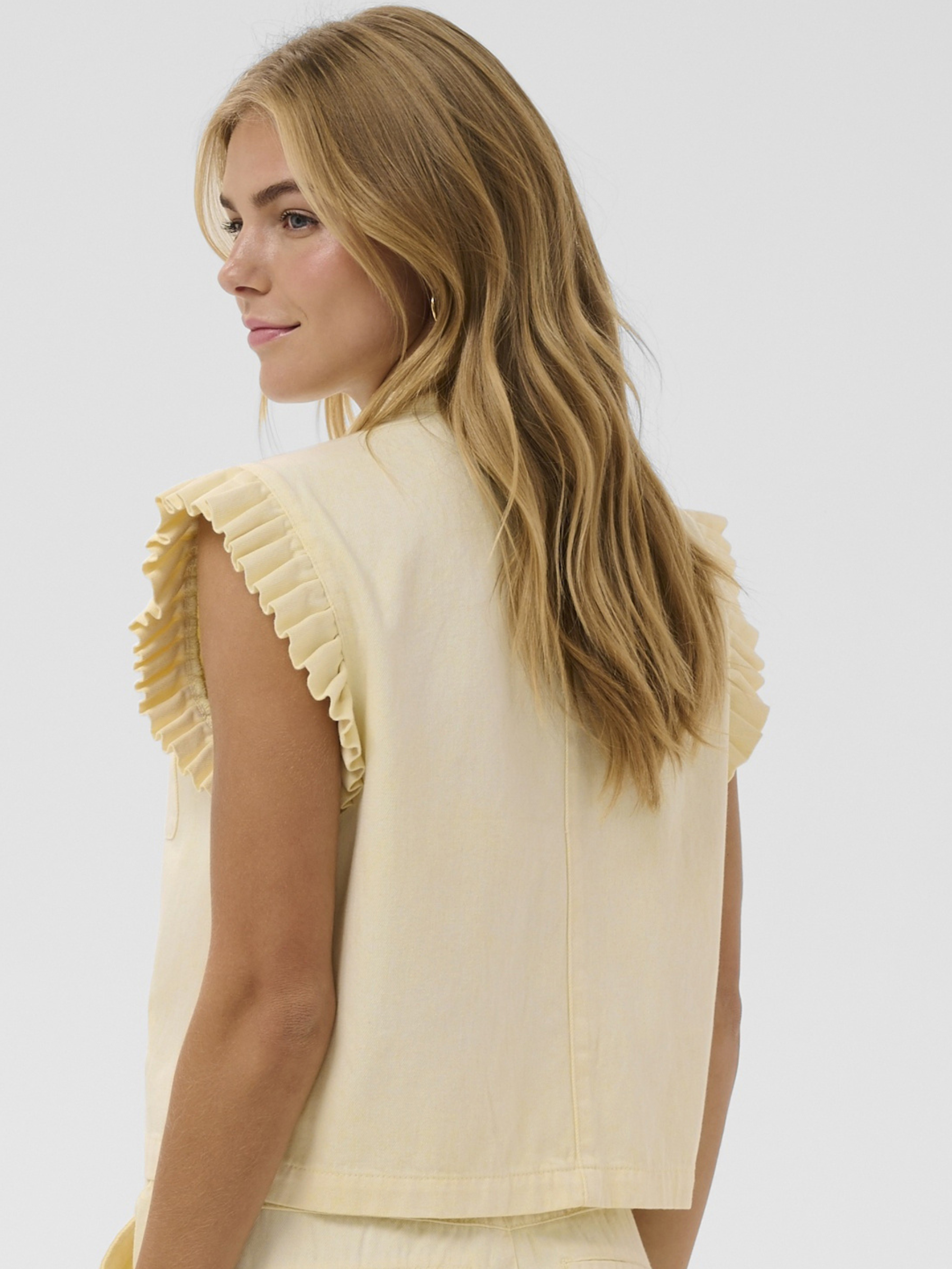 Cream Lorra Waistcoat with frill shoulder detail, single top button fastening and front pockets.