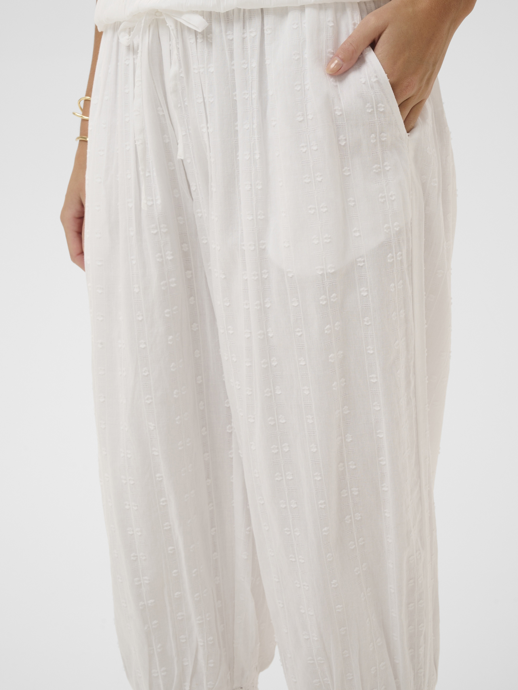 Cream Sereni Pant with textured cotton fabric, elasticated waist, lace trim and frill hem.