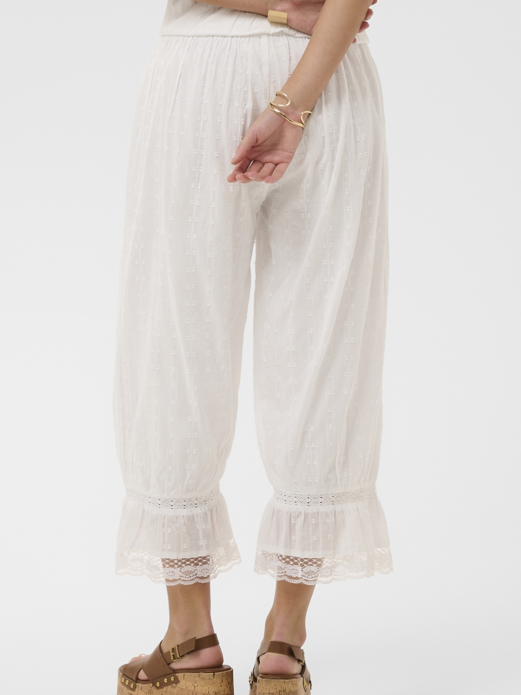 Cream Sereni Pant with textured cotton fabric, elasticated waist, lace trim and frill hem.