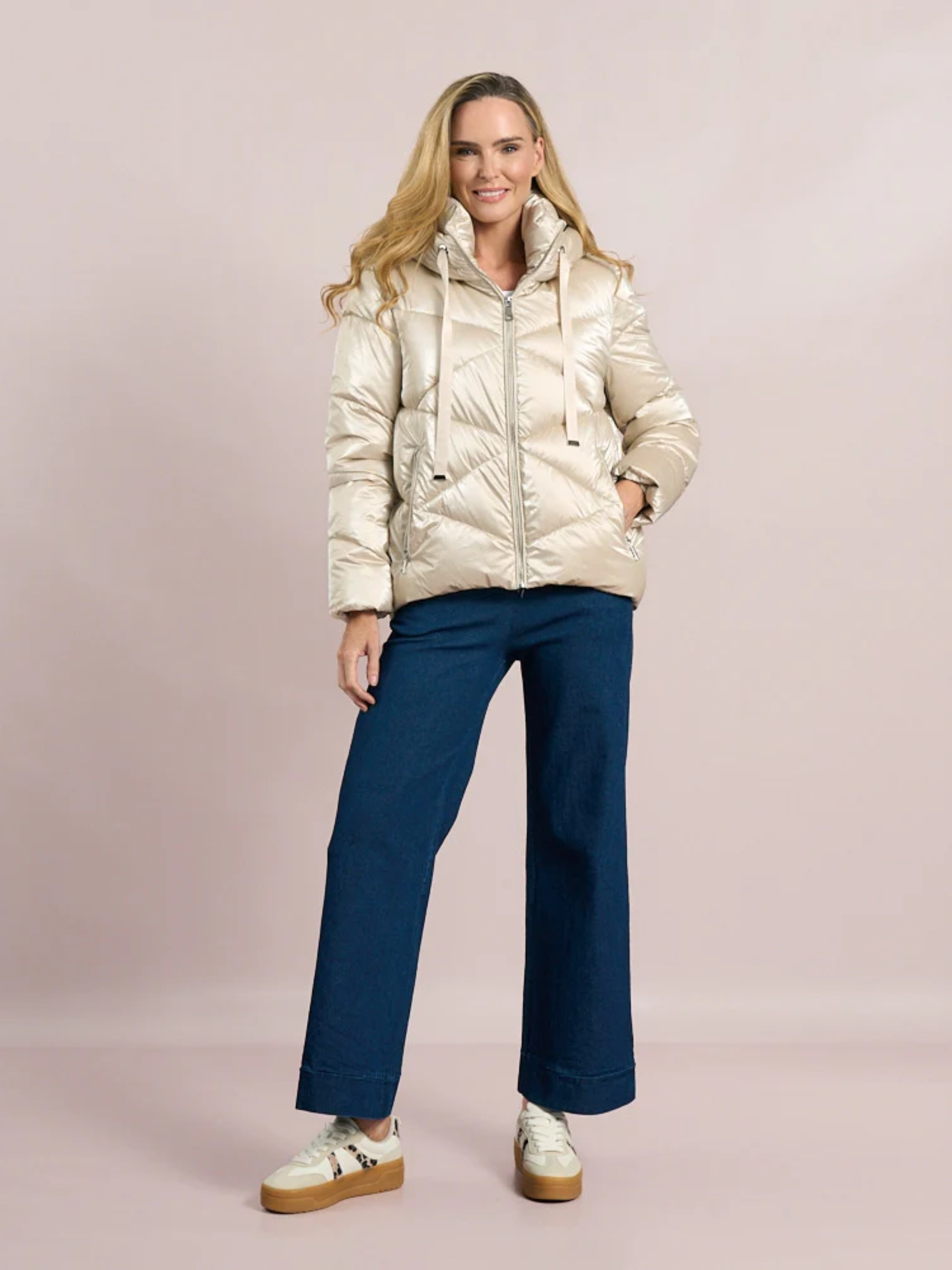 Women's champagne puffer coat with high neck and hood by Deck by Decollage - stylish quilted winter jacket with front zip, drawstring details, and cosy padded design for cold weather layering.