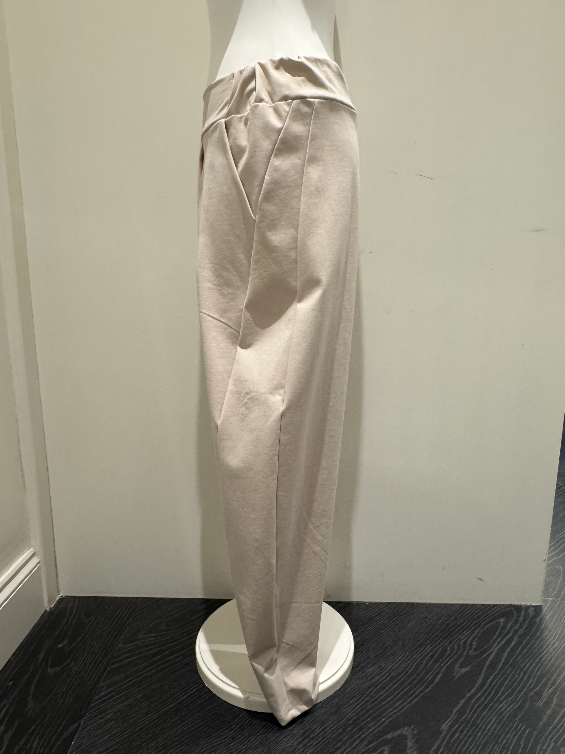 Deck by Decollage tapered sand trousers with a wide waistband, soft pleats, and ankle-length fit. Designed for a sleek, flattering silhouette in a neutral tone-perfect for smart-casual styling.