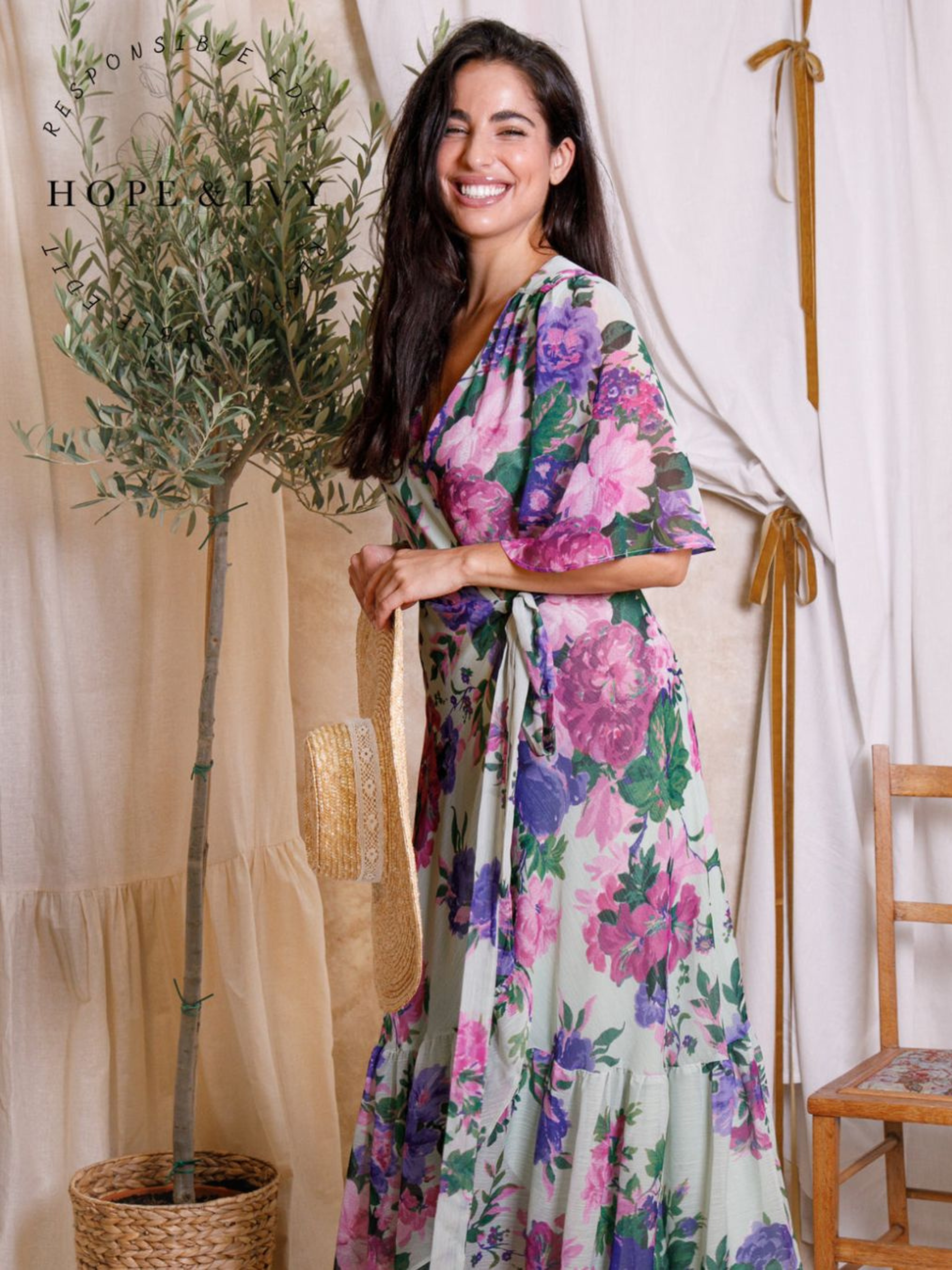 Hope & Ivy Priscilla Floral Dress – sustainable sage-green floral maxi wrap dress with flutter sleeves and tie waist. Made from 100% recycled materials. Perfect for weddings and summer occasions.