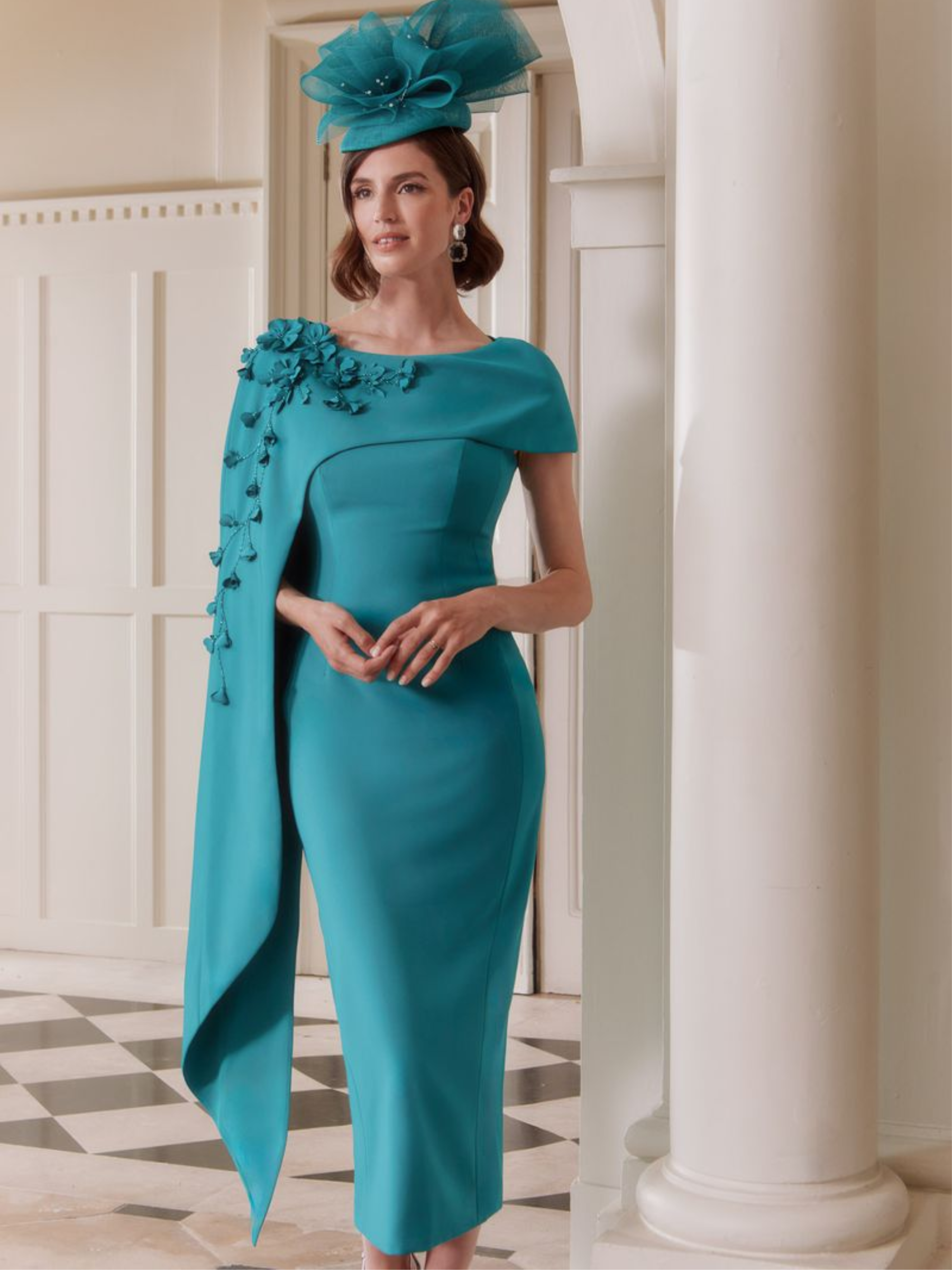 John Charles 29303 Peacock Dress with asymmetric floral-appliqué cape, sculpted crepe bodice and fitted midi pencil skirt — a sophisticated peacock-blue occasion dress perfect for weddings and formal events.