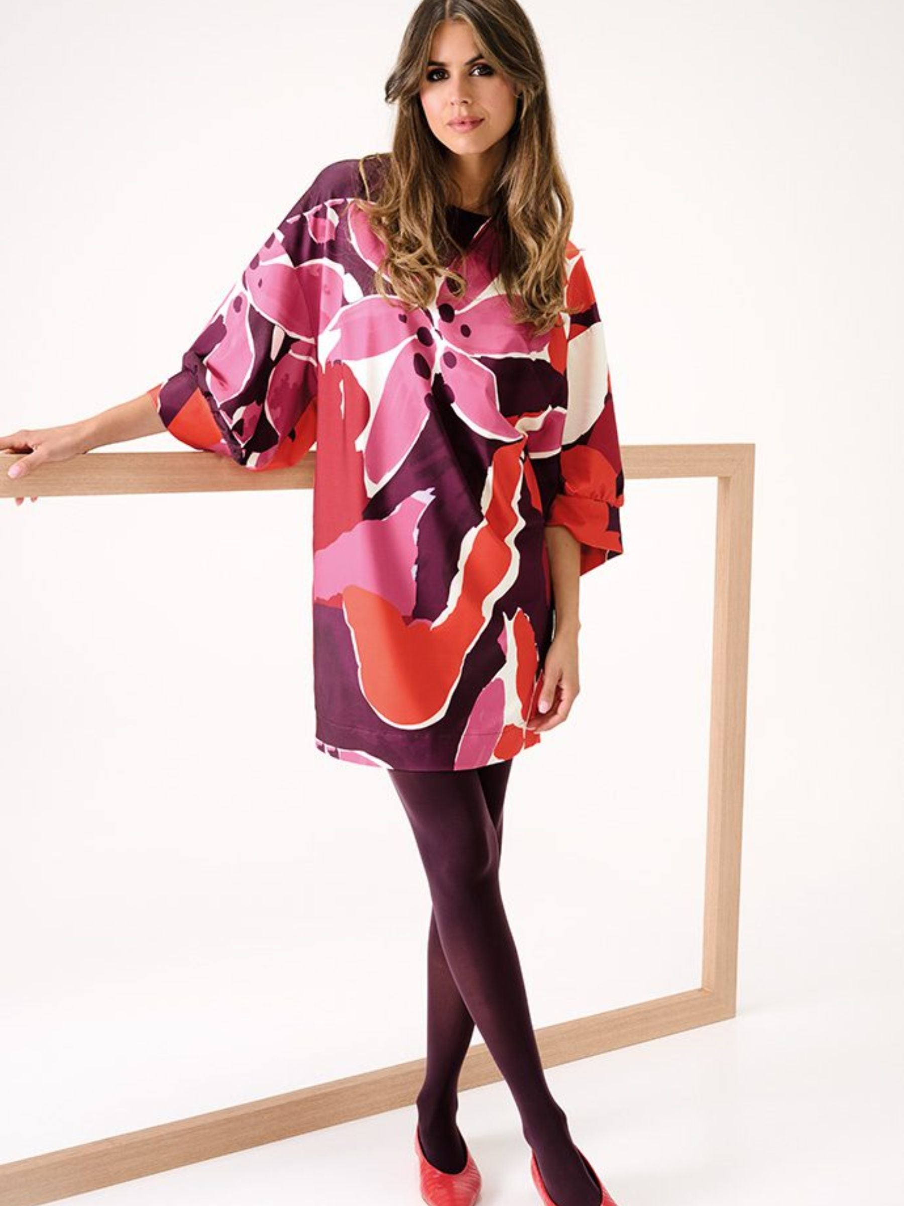 Women’s dress featuring a bold floral print in vibrant red, pink, and purple tones, with oversized batwing sleeves and a relaxed silhouette - a stylish statement dress for casual or smart occasions.