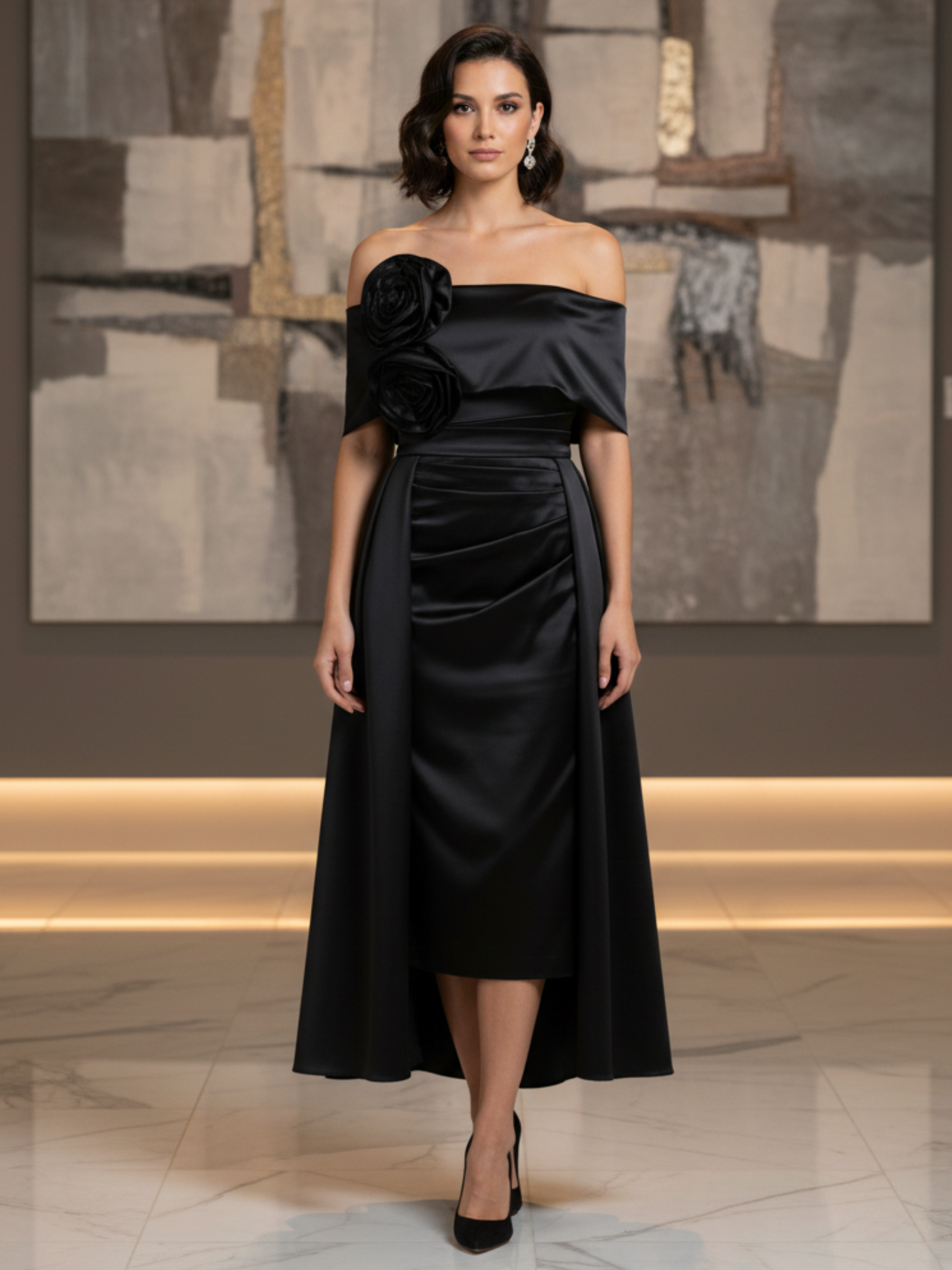 Kevan Jon Kris Black Dress with bardot neckline, ruched bodice, fitted skirt, flowing overskirt and oversized rosette detail.