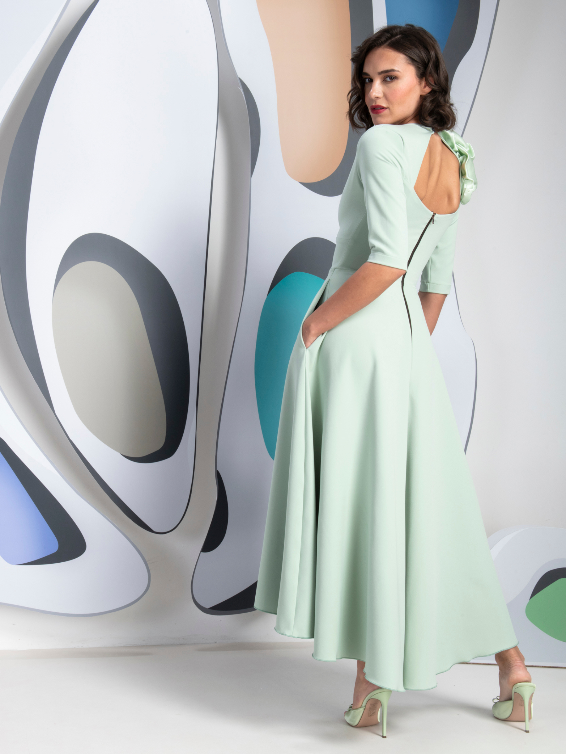 Kevan Jon Betty B Mint 3 Rosettes Dress in Delauney Duchess fabric with a V-neckline, sculptural shoulder rosettesand flowing high-low flared skirt.