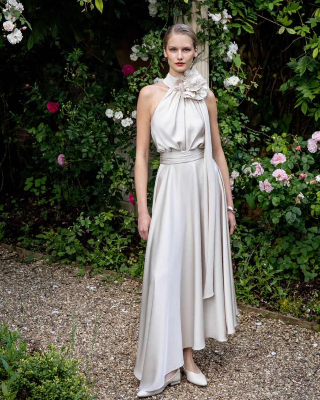 Maisonel ME3004 Oyster Dress – women’s halter neck satin occasion dress in elegant oyster tone with floral applique and asymmetric hem, perfect for weddings and formal events.