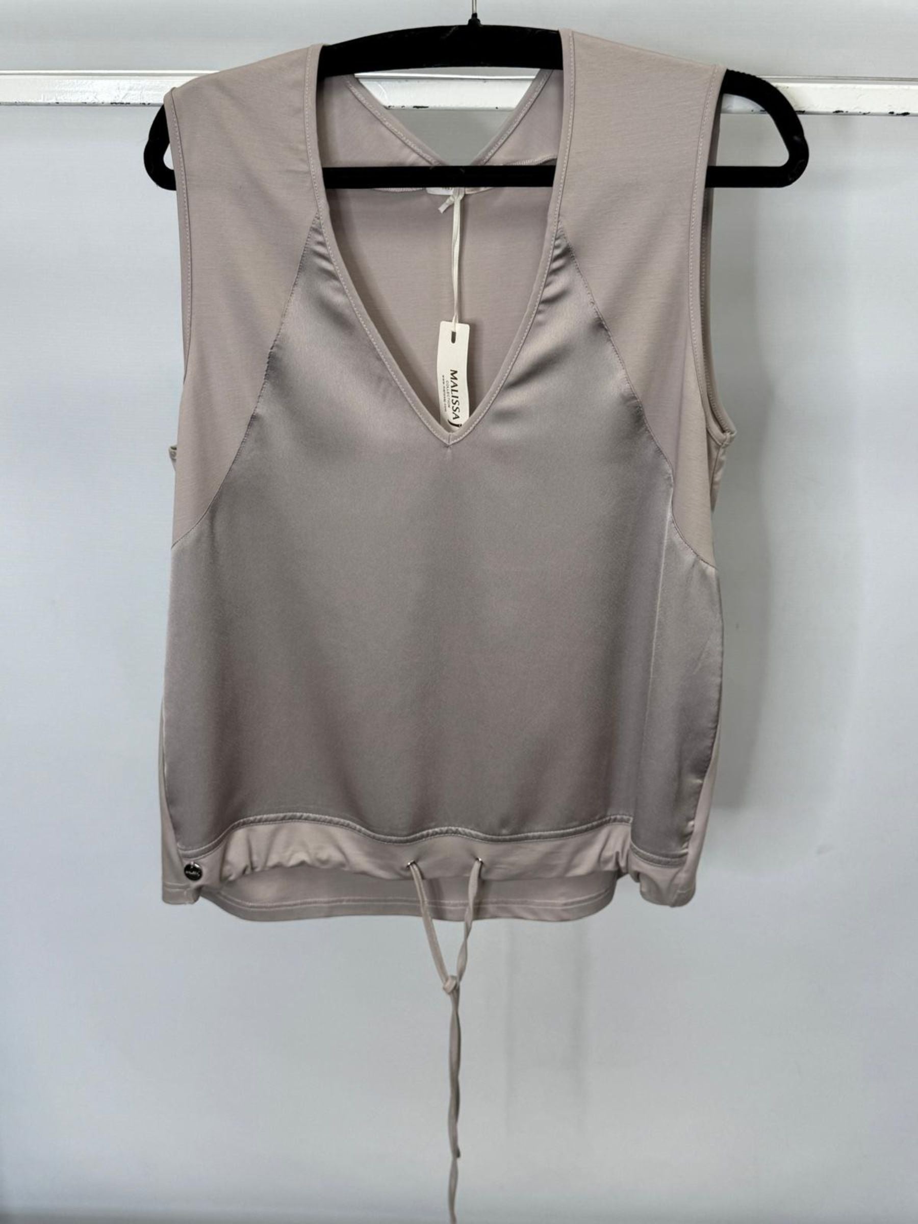 Beige tank top with a tag on a hanger against a white background