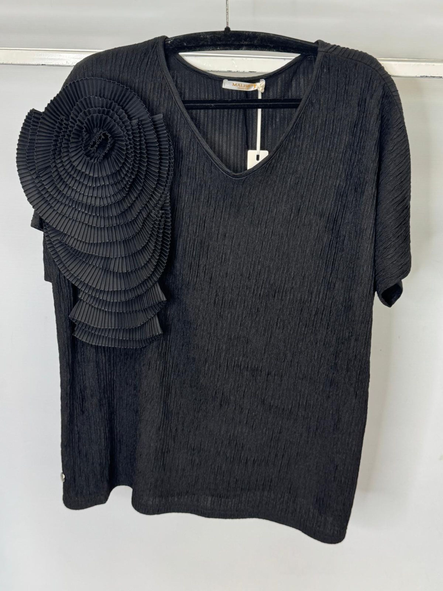 Black sweater with floral embellishment on a white background