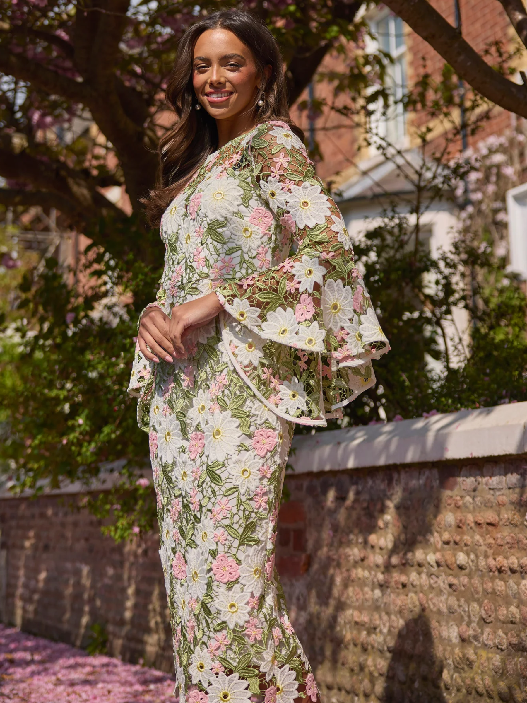 The 8th Sign 8SS605 pink rosaline lace midi dress with floral lace detailing and flared sheer sleeves.