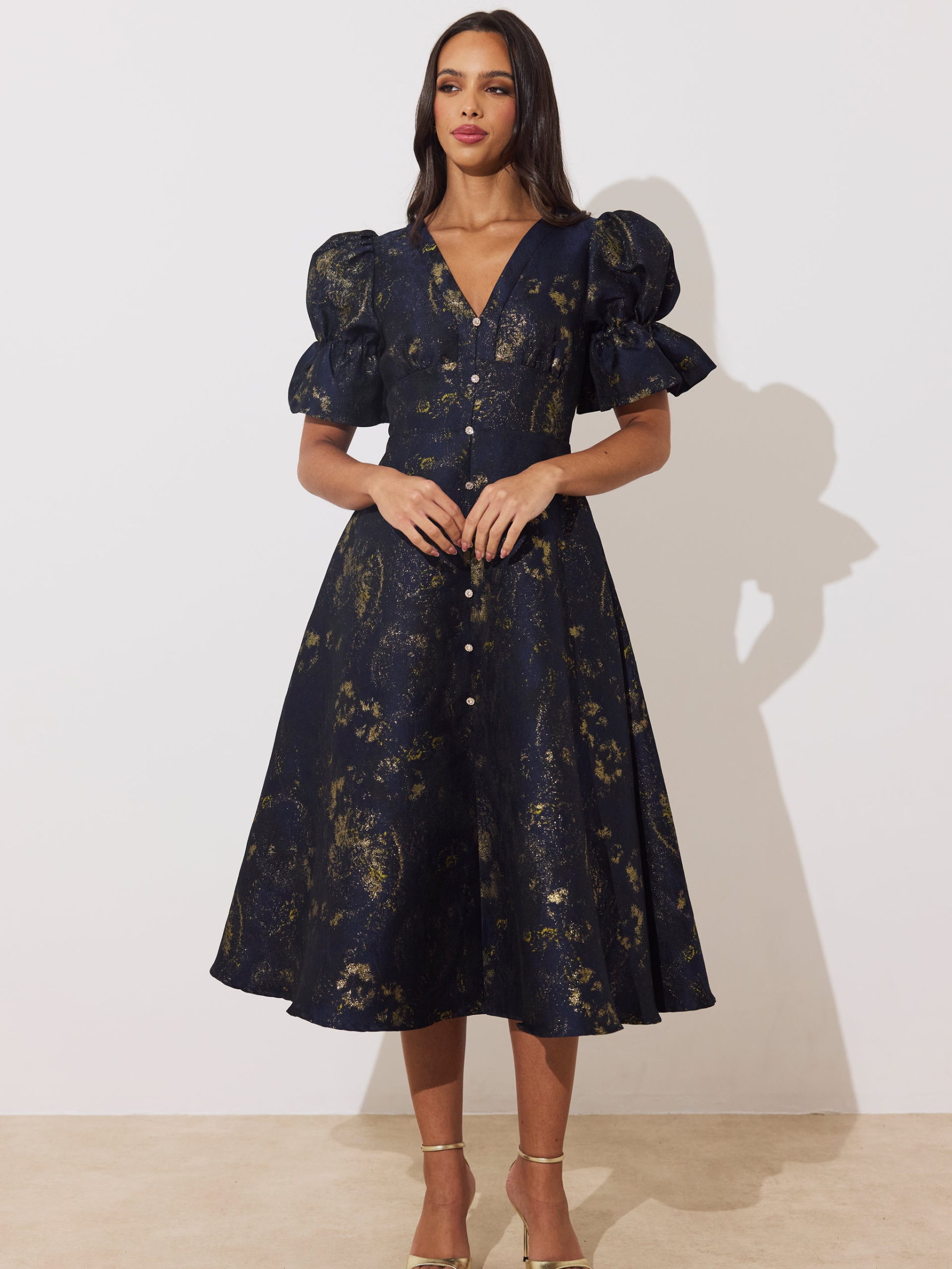 The 8th Sign Callie Metallic Skater Dress with V-neckline, puff sleeves, button-front detail and flared skirt.