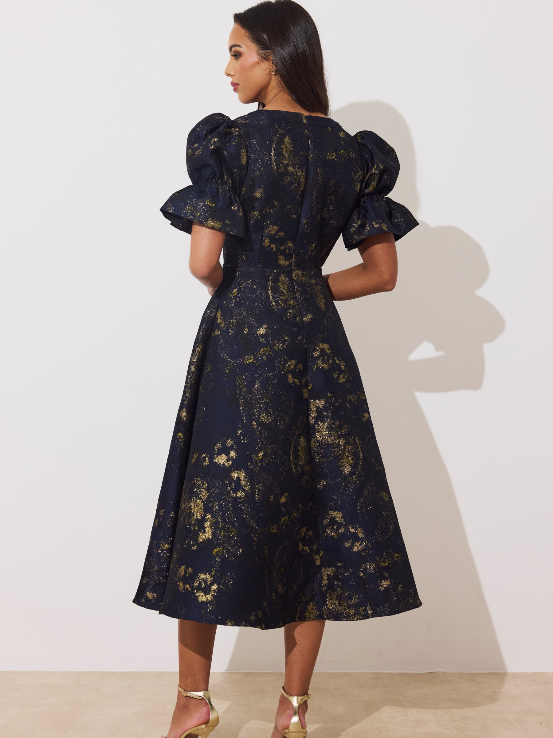 The 8th Sign Callie Metallic Skater Dress with V-neckline, puff sleeves, button-front detail and flared skirt.