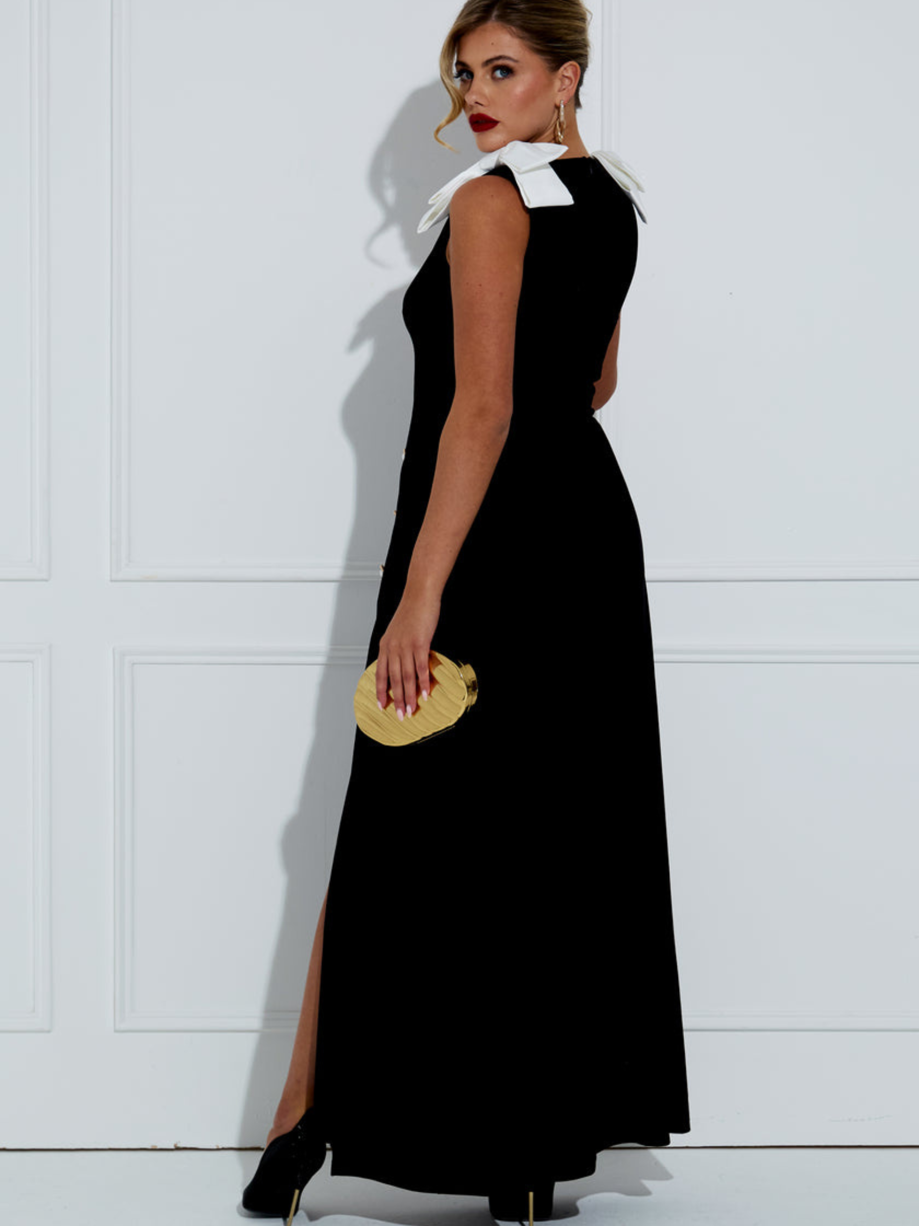 The 8th Sign Joan Velvet Bow Maxi Dress with V-neckline, shoulder bow detail, decorative buttons and front split.