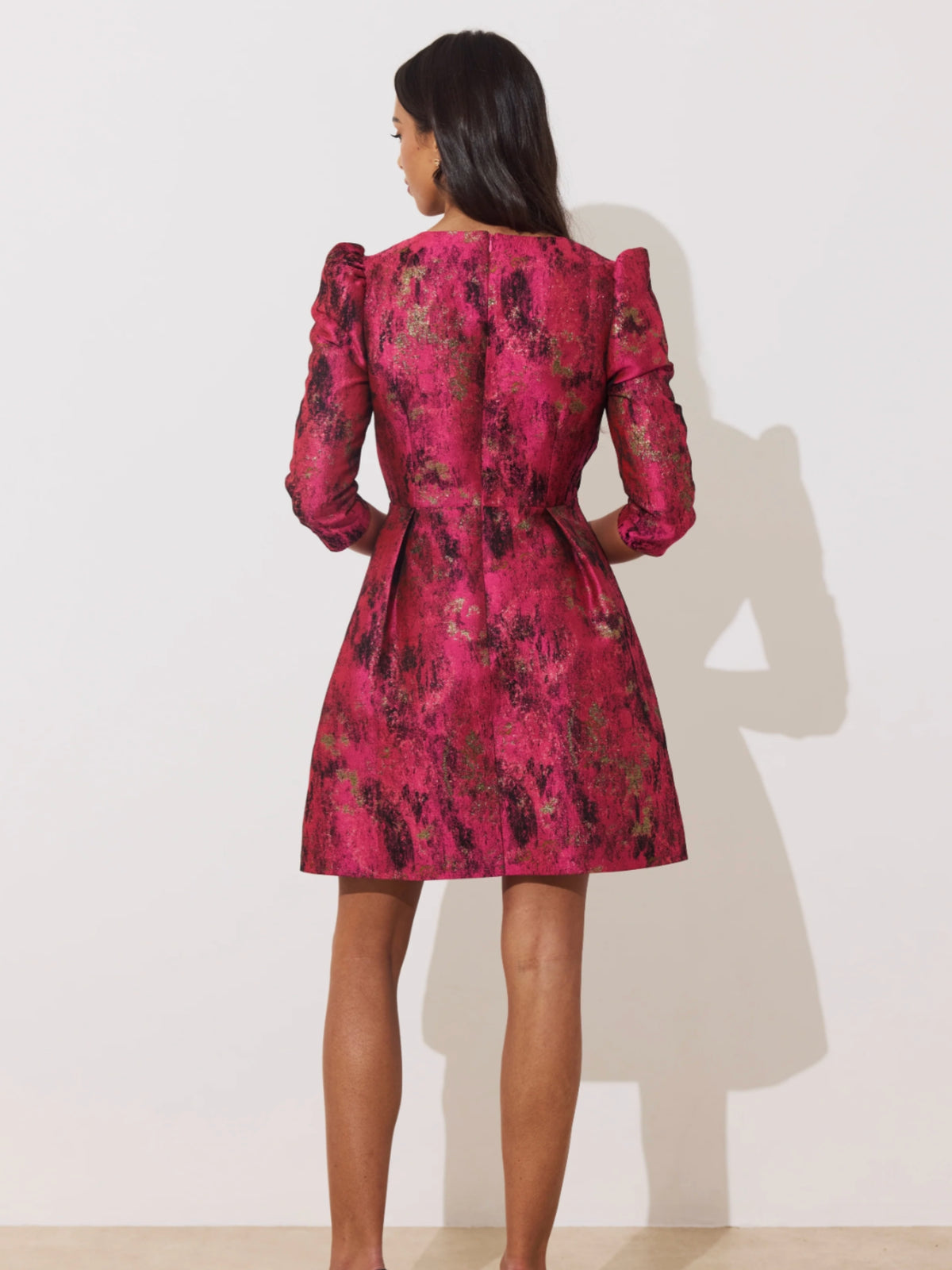 The 8th Sign Veronica Metallic Mini Dress with deep V neckline, statement bow detailing, puff shoulders and A-line skirt.
