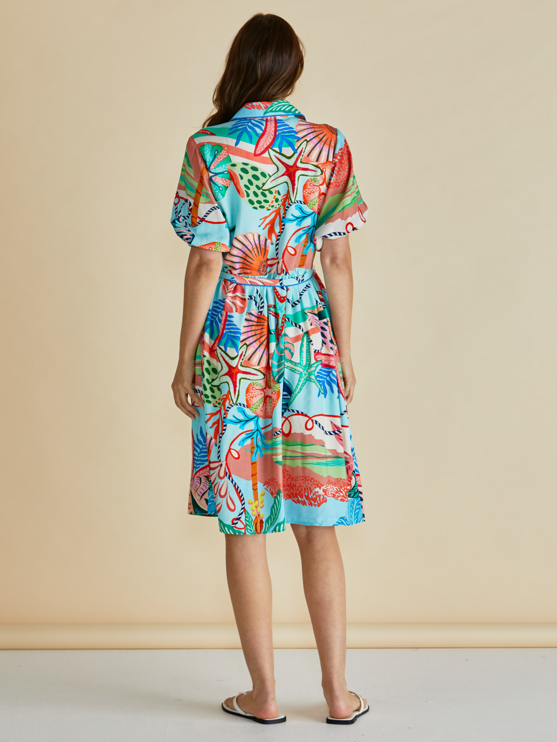 Betty Rio Reef Dress with shirt collar, button-through front, puff sleeves and self-tie waist belt.
