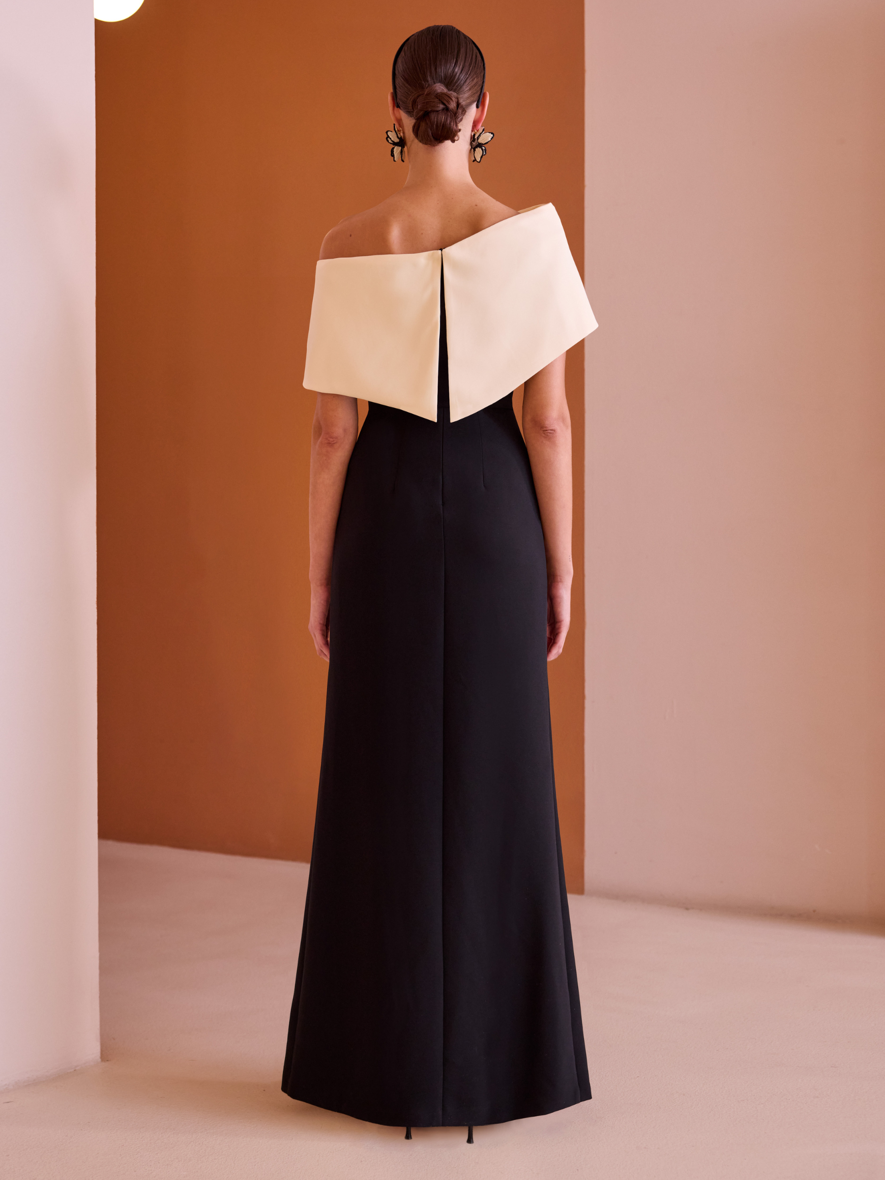 Carla Ruiz 52546 Black Dress with asymmetric off-shoulder neckline, monochrome sculpted panels and flowing A-line skirt with pleated detail.