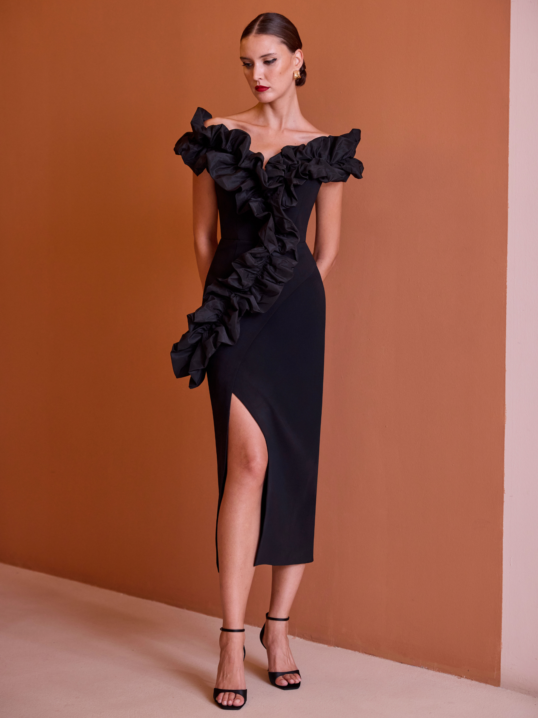 Carla Ruiz 52606 black fitted dress with off-the-shoulder neckline, ruffle detailing and front split.