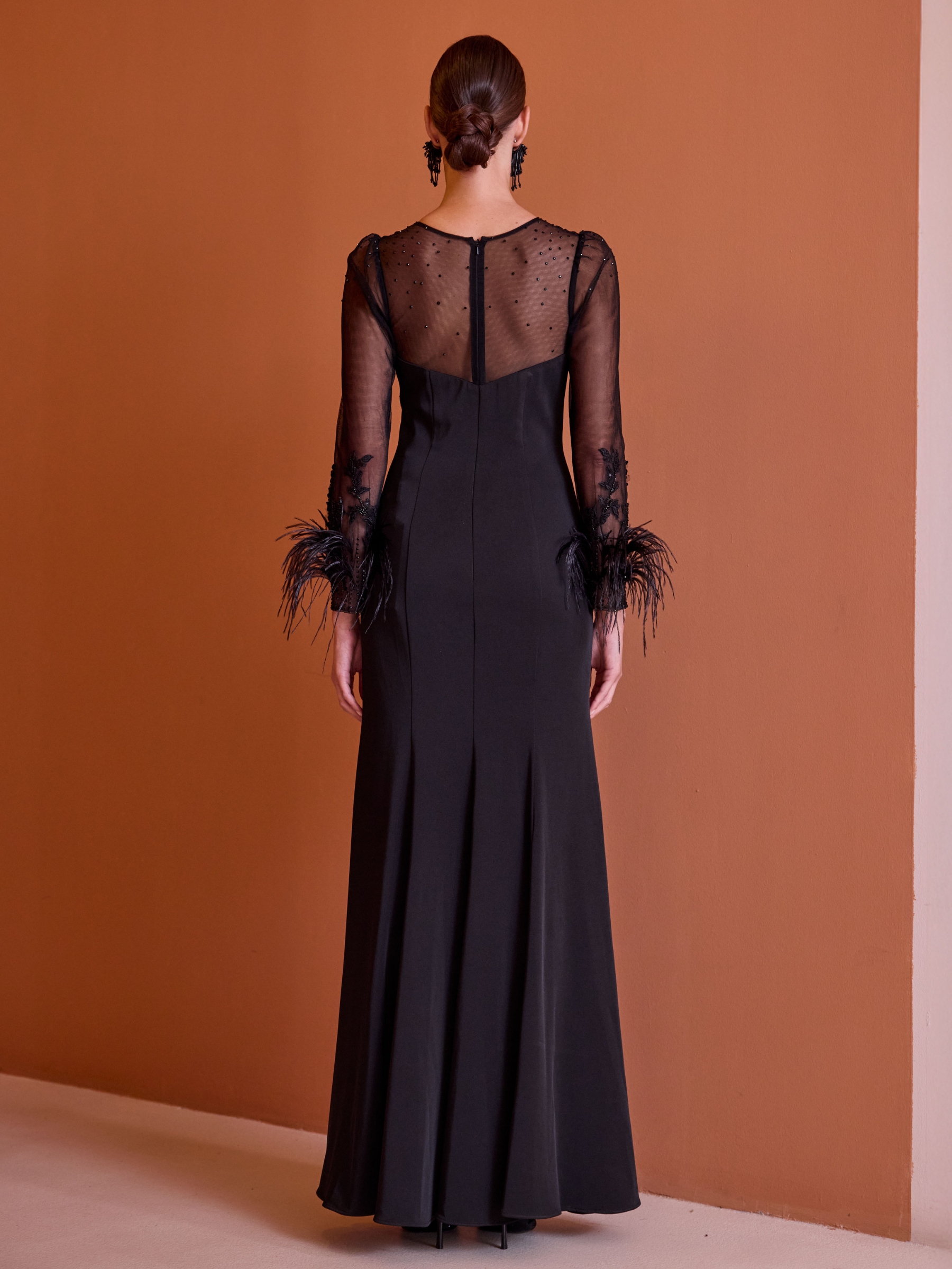 Carla Ruiz 52729 black dress with sheer embellished bodice, long sleeves, feather cuffs and front split.
