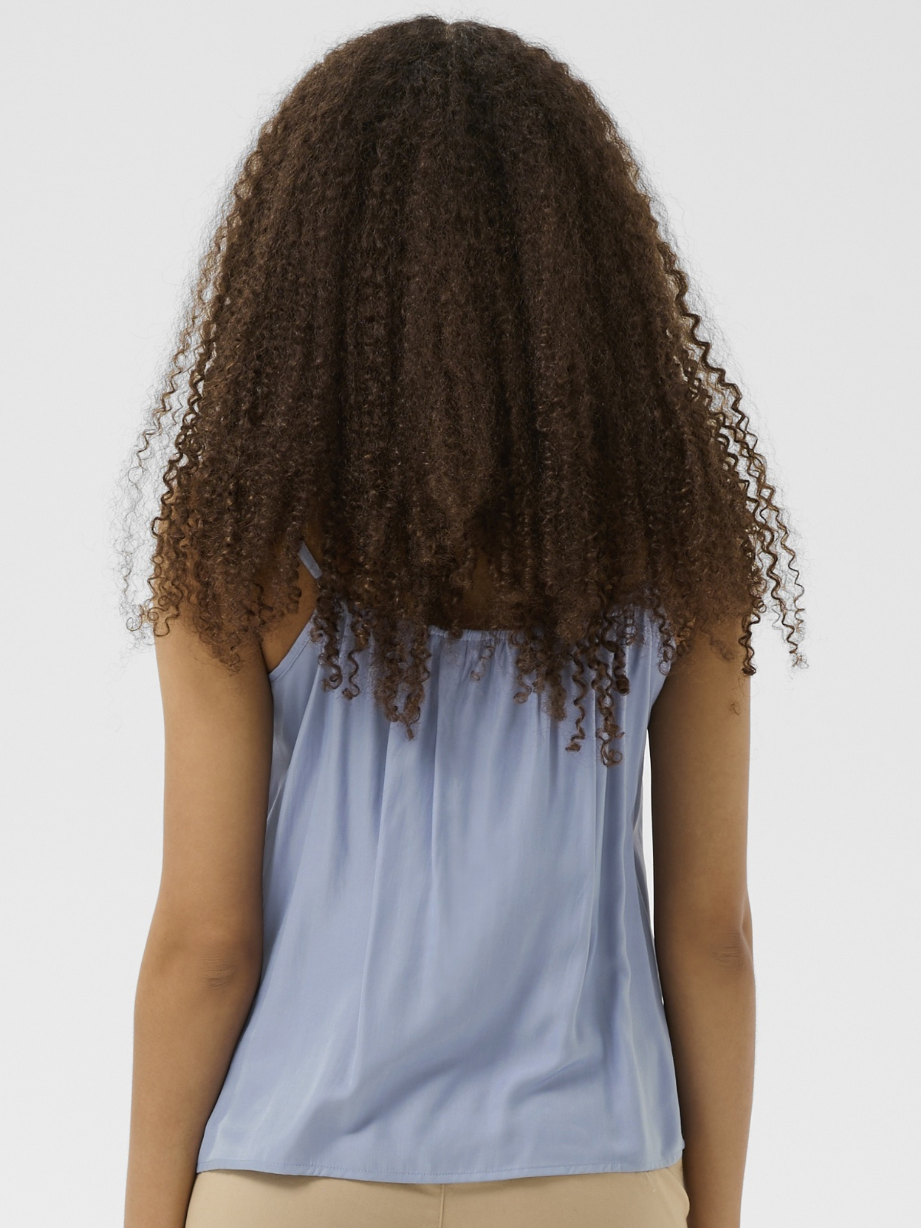 Cream Anna women’s A-line camisole top with lace neckline detail, adjustable straps and hip-length fit, styled with jeans.