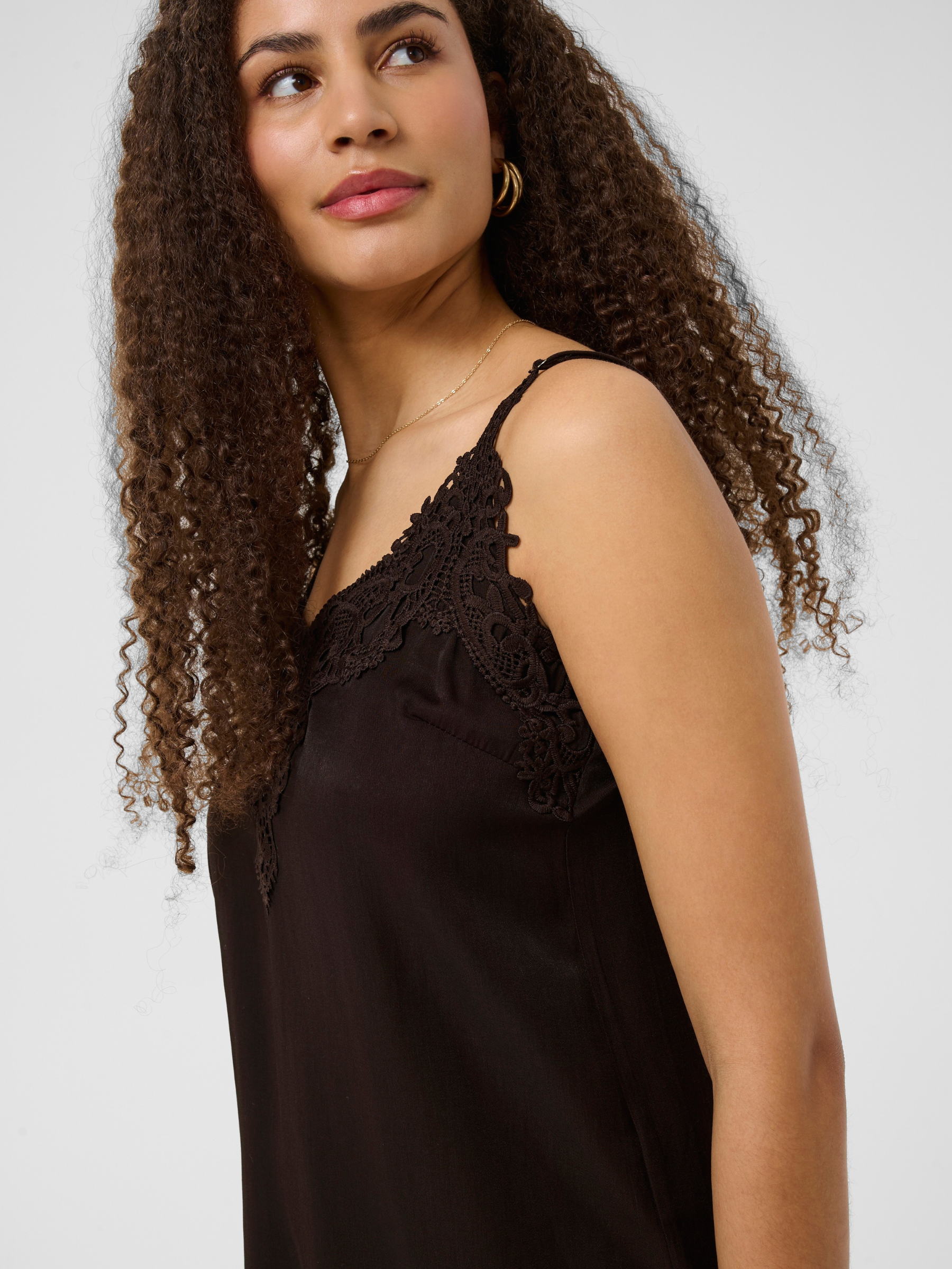 Cream Anna women’s A-line camisole top with lace neckline detail, adjustable straps and hip-length fit, styled with jeans.