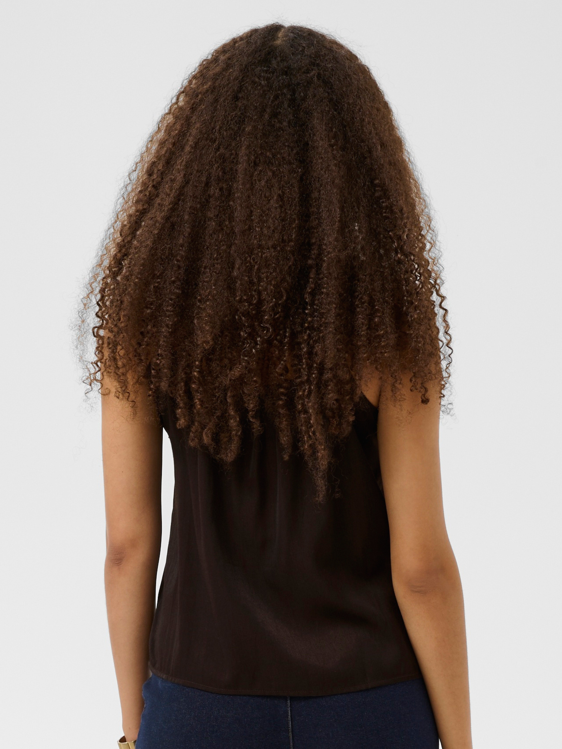 Cream Anna women’s A-line camisole top with lace neckline detail, adjustable straps and hip-length fit, styled with jeans.
