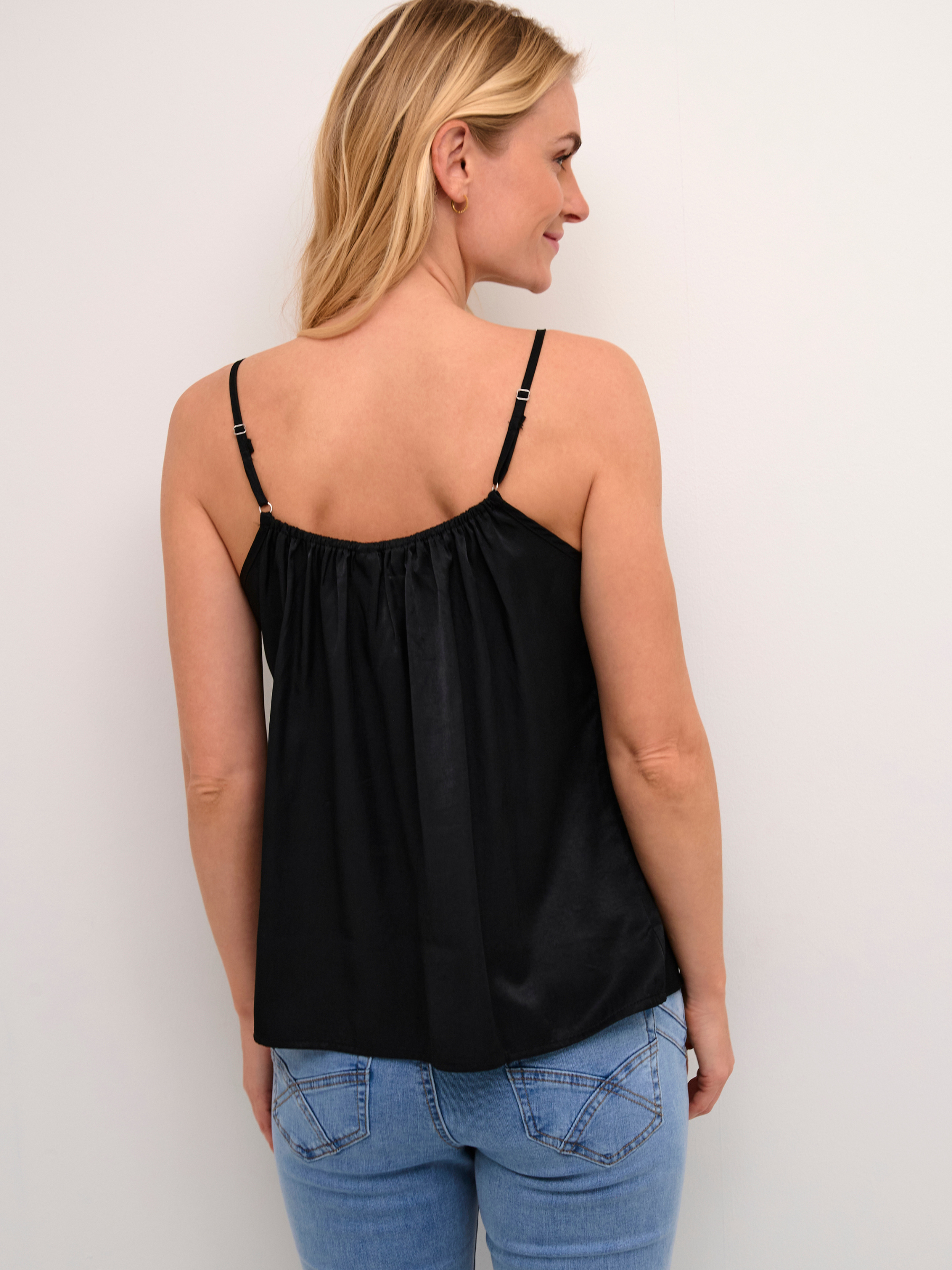 Cream Anna women’s A-line camisole top with lace neckline detail, adjustable straps and hip-length fit, styled with jeans.