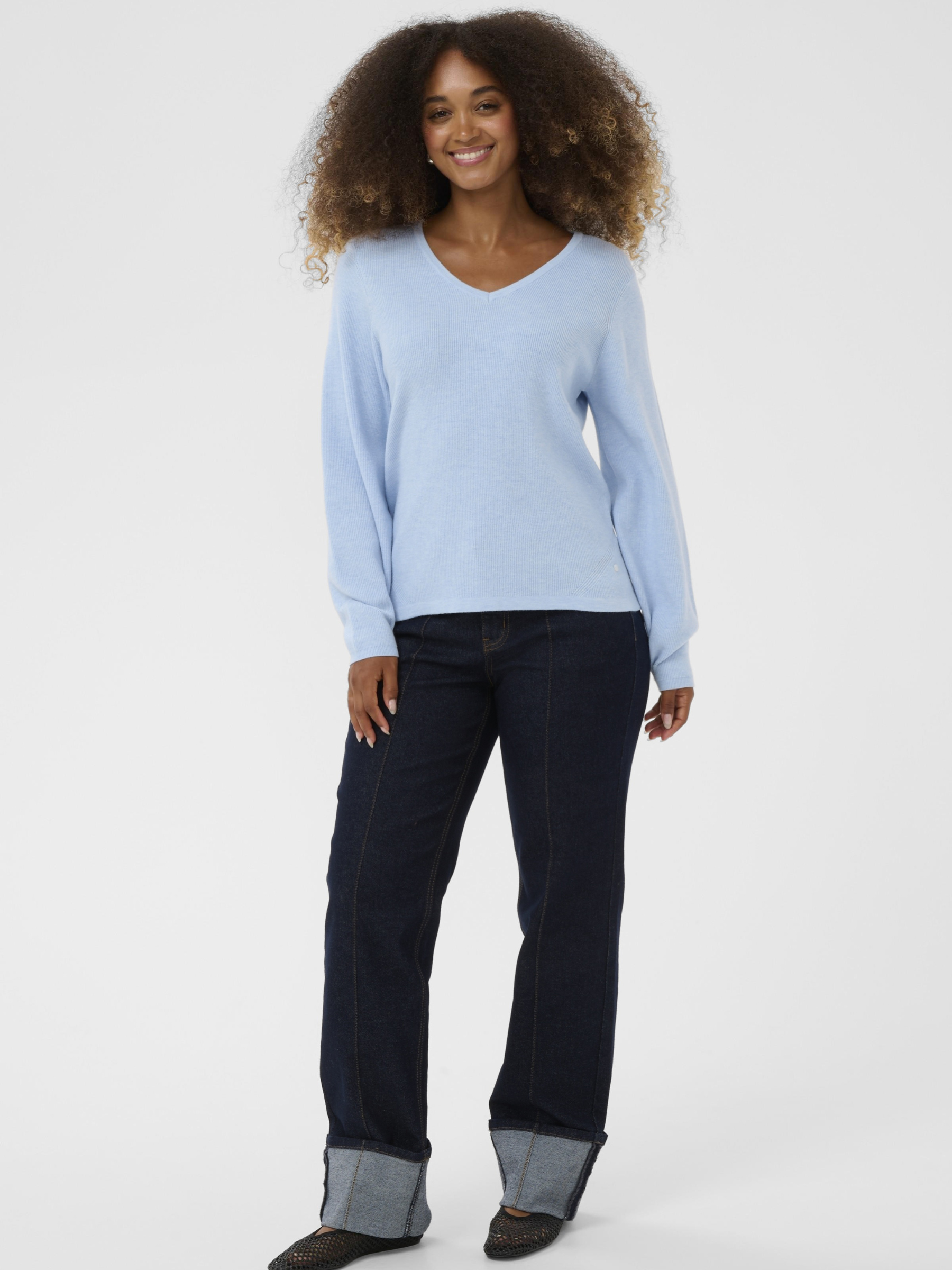 Cream Dela Knit Blouse women’s relaxed fit long-sleeve knit top with a soft drape and hip-length cut, styled casually.