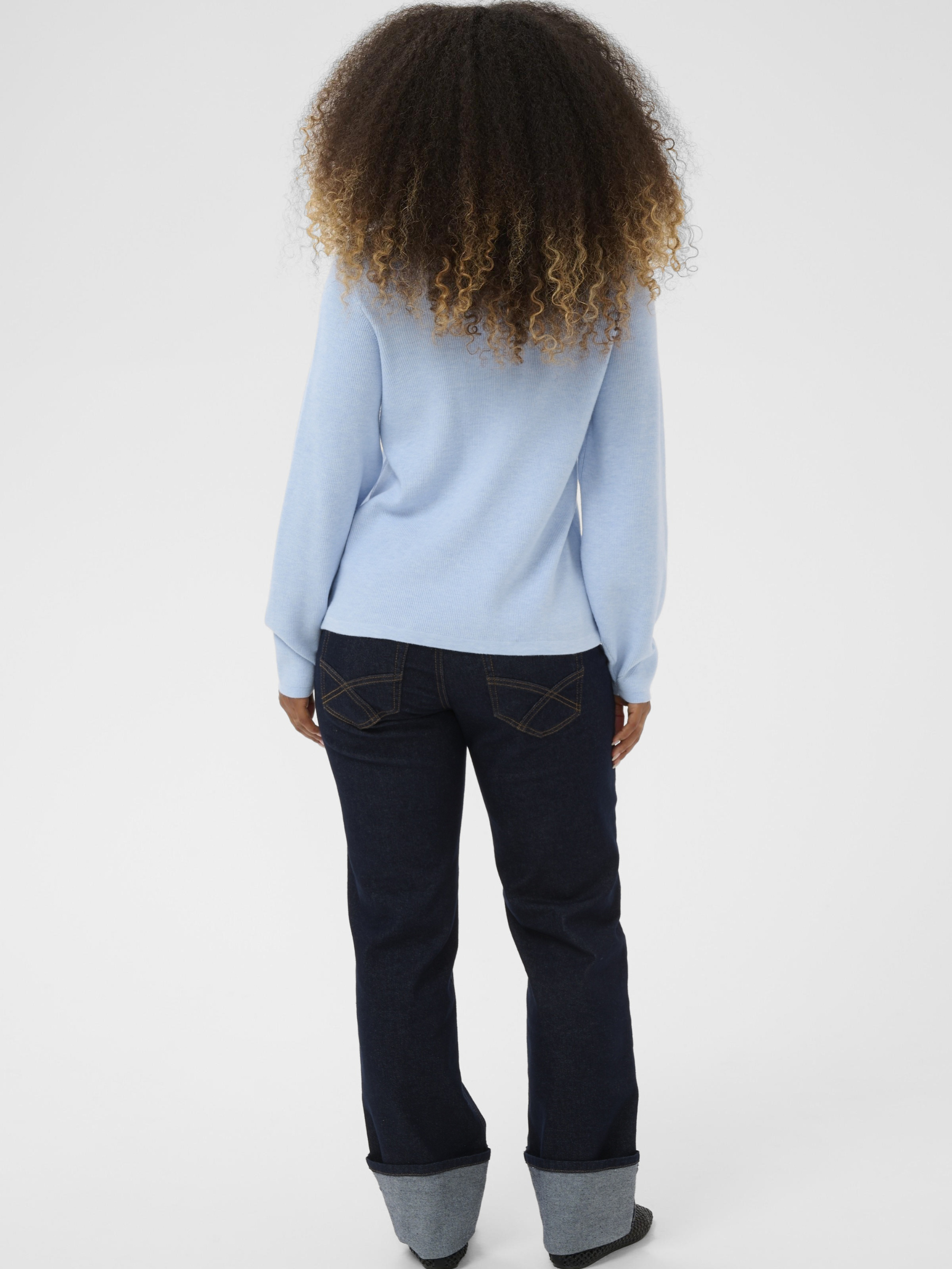 Cream Dela Knit Blouse women’s relaxed fit long-sleeve knit top with a soft drape and hip-length cut, styled casually.