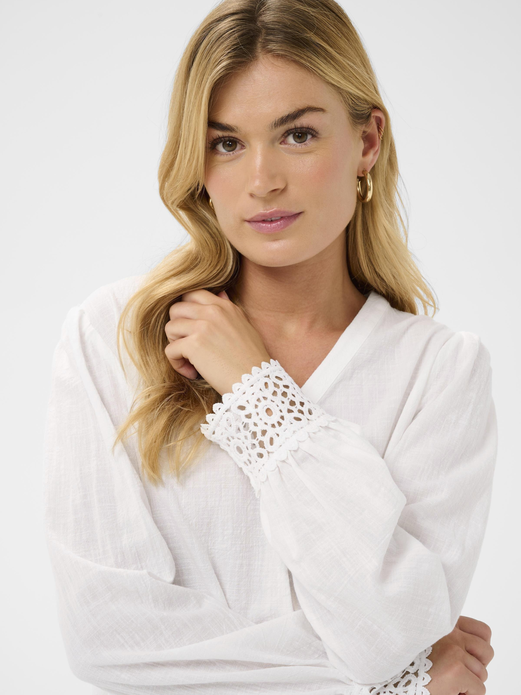 Cream Delia white V-neck blouse with long sleeves and lace cuff detailing in lightweight cotton.