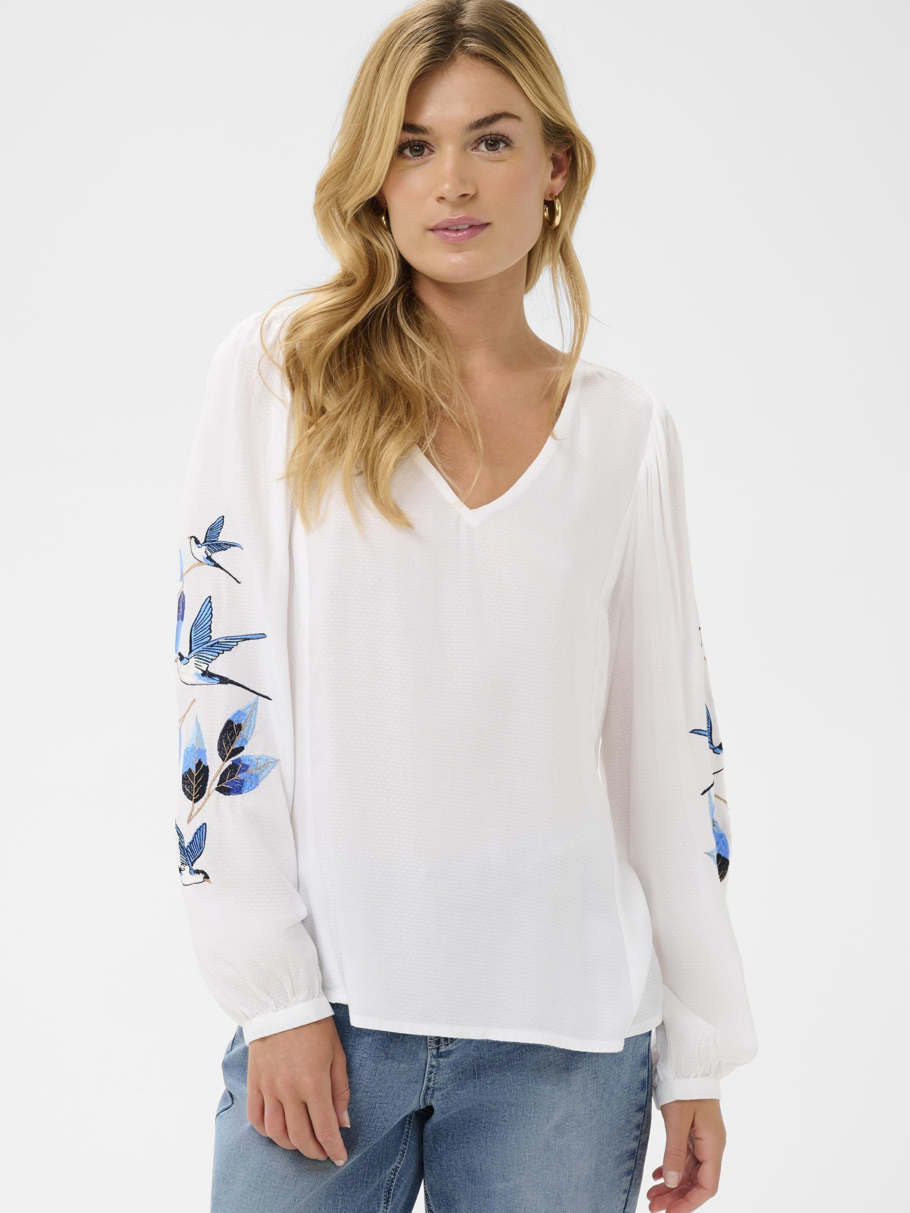 Cream Floriza V-neck blouse with embroidered blue bird detail on sleeves in lightweight viscose.