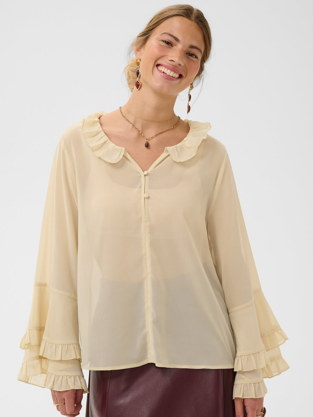 Cream Flouncy Blouse with ruffle neckline, button front and layered flared sleeves.
