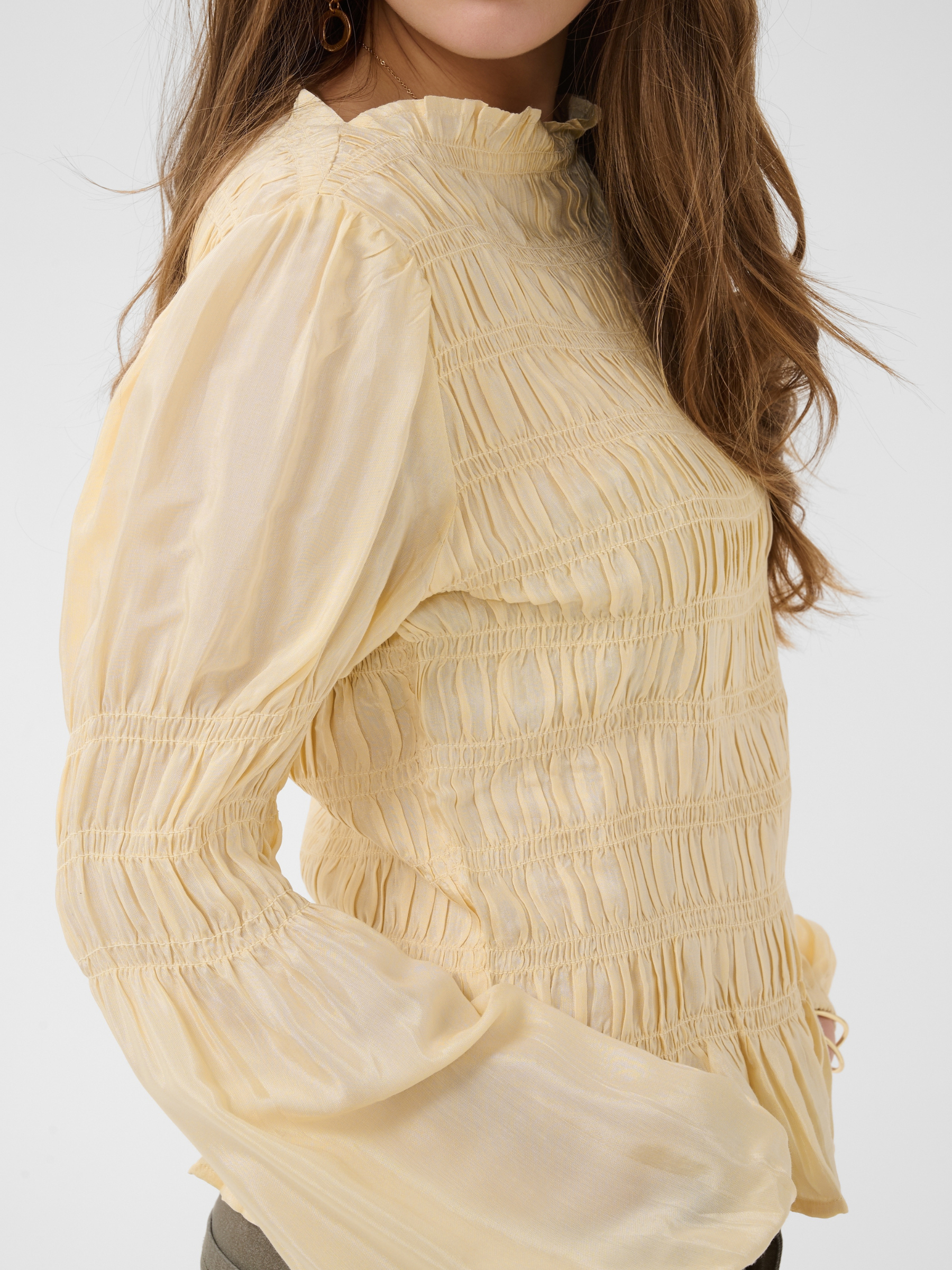 Cream Henva Blouse with shirred texture design and frill hem.
