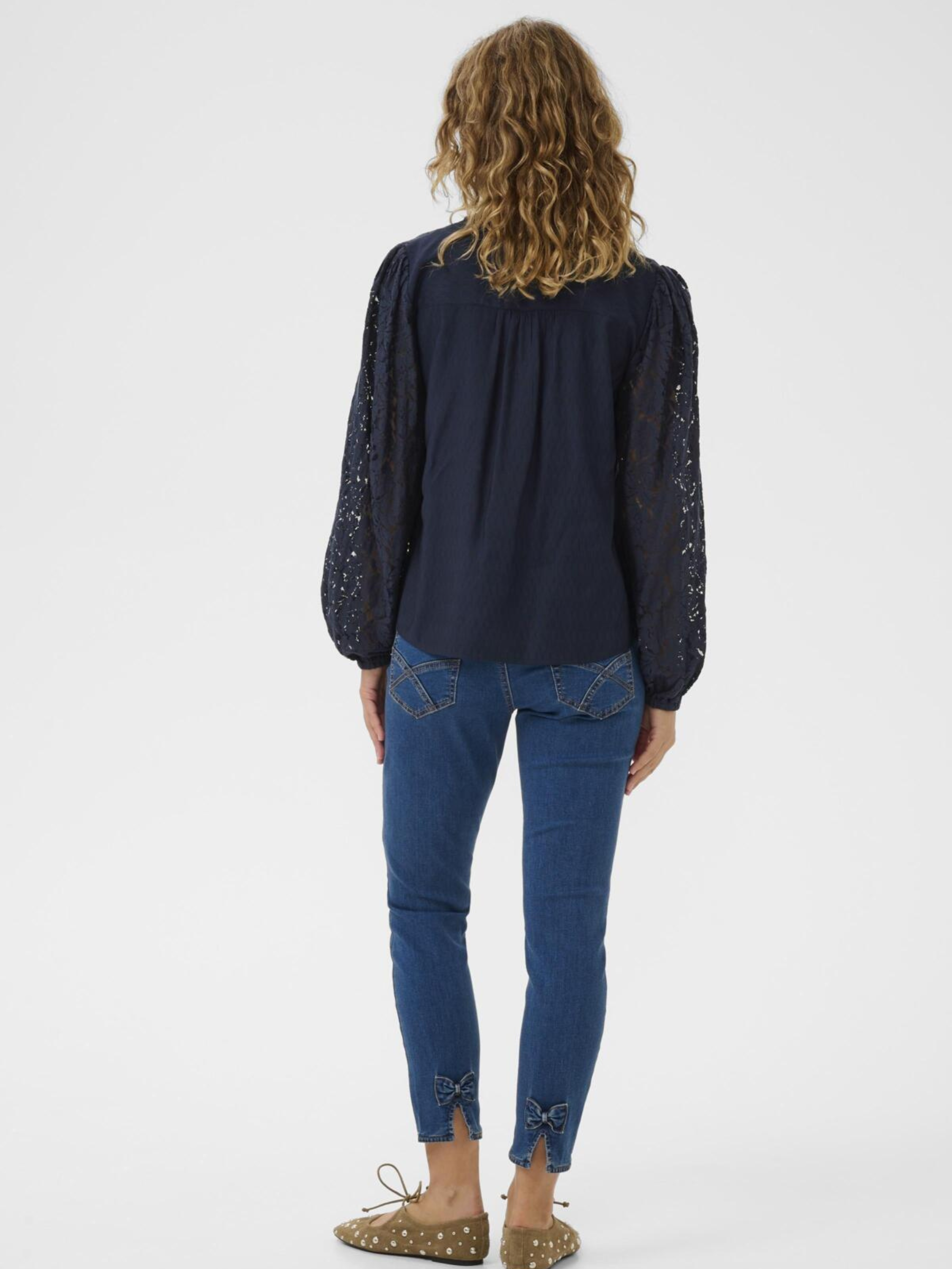 Cream Liselin Lace Blouse women’s regular-fit blouse with lace sleeves, split neckline and hip-length silhouette, styled with jeans.