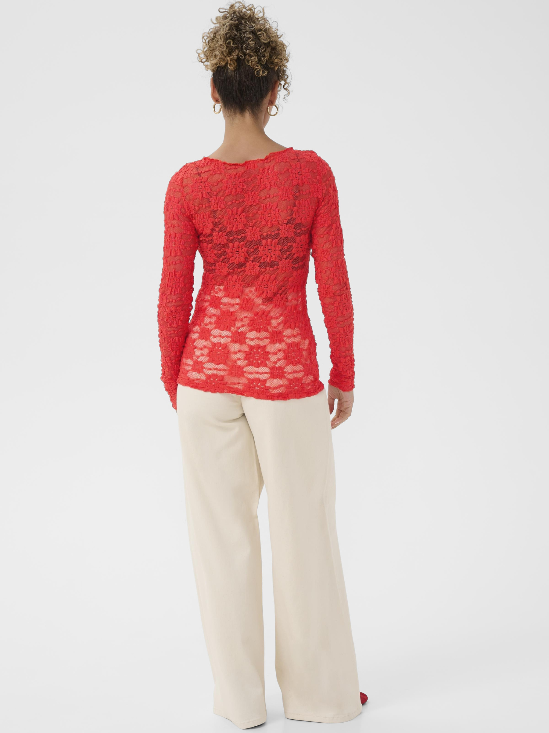 Cream Maddie Blouse women’s slim-fit lace top with long sleeves and hip-length silhouette, styled with trousers.
