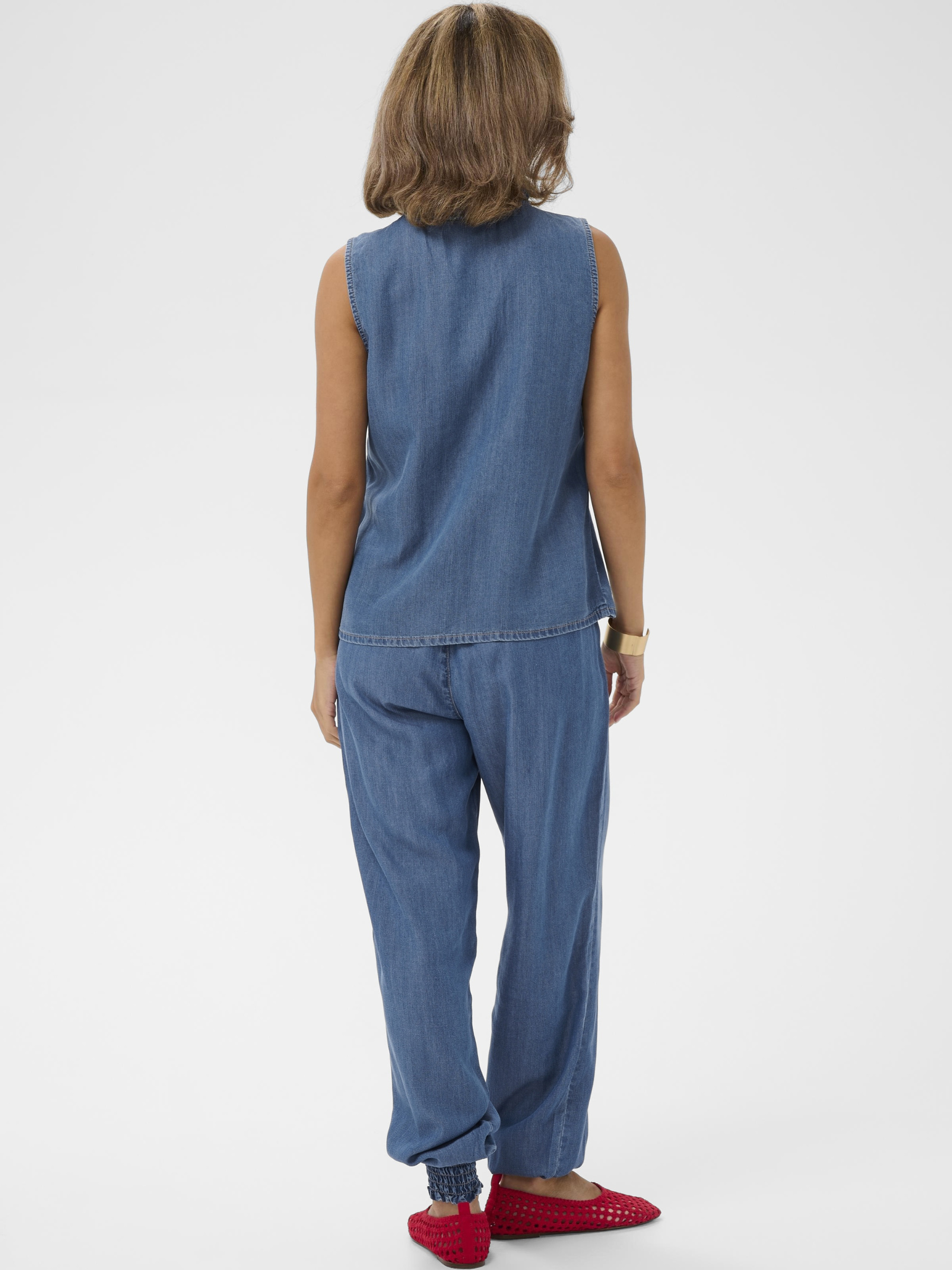 Cream Molly Sleeveless Blouse in soft lyocell with V-neckline and ruffle front detail.