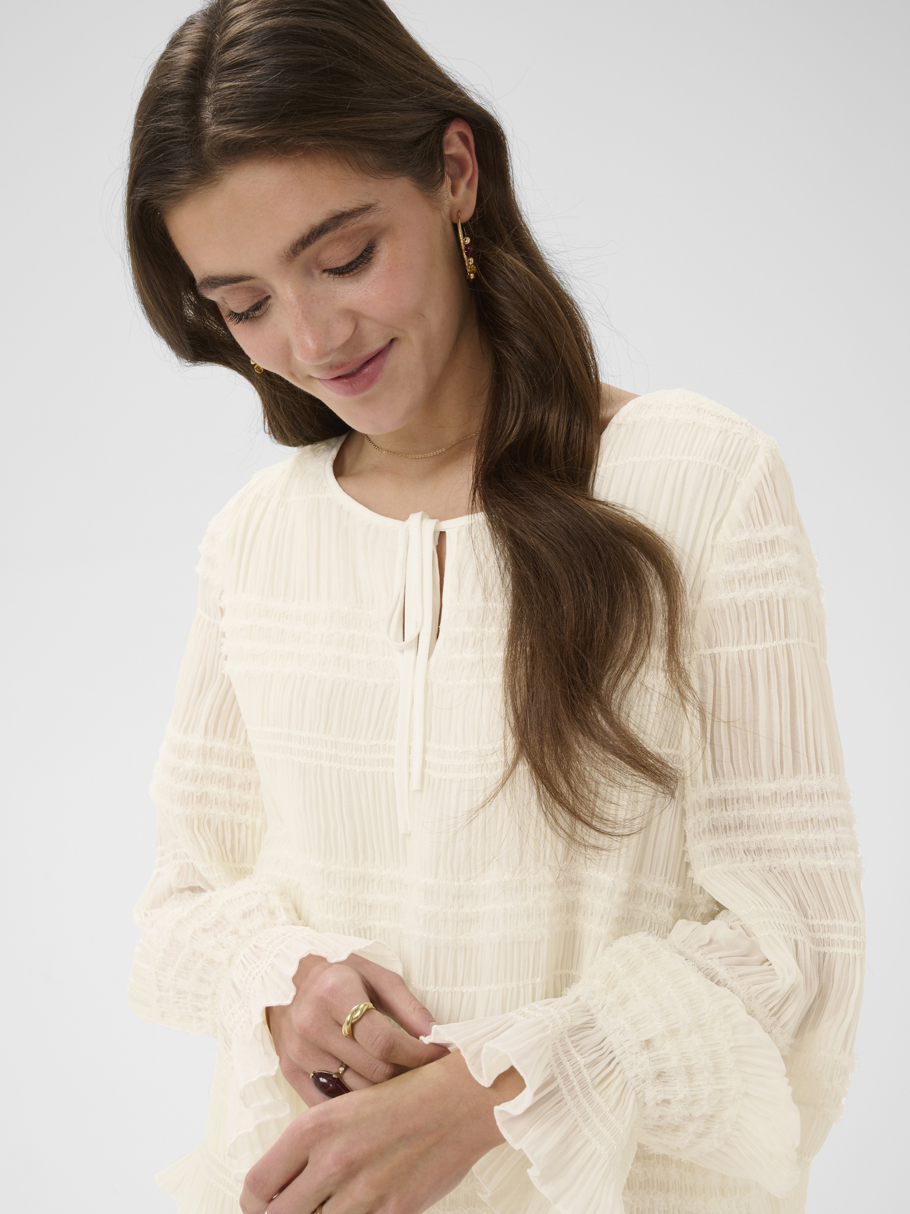 Cream Sissel Blouse with pleated texture, tie neckline and long fluted sleeves in a regular fit.