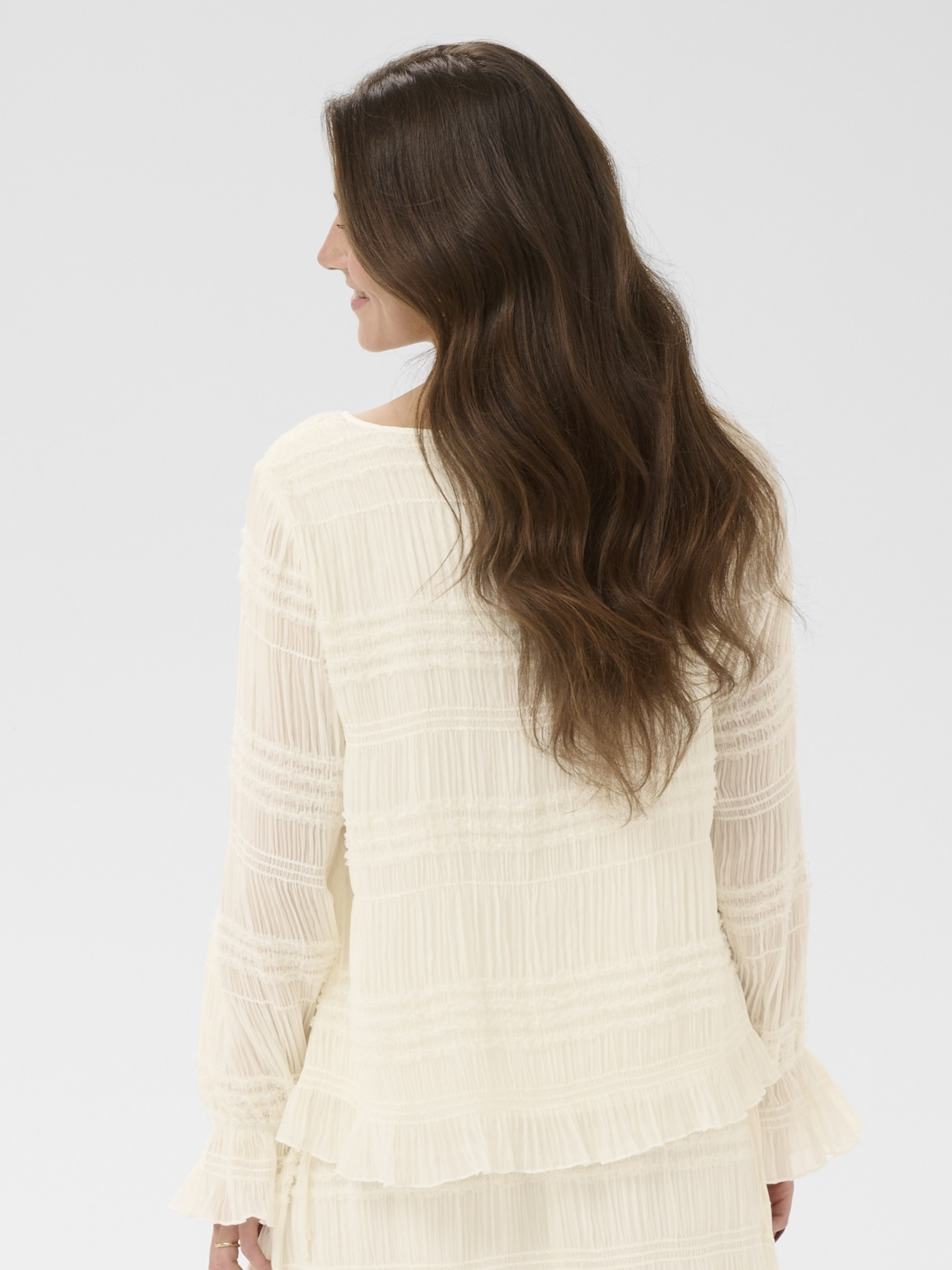 Cream Sissel Blouse with pleated texture, tie neckline and long fluted sleeves in a regular fit.