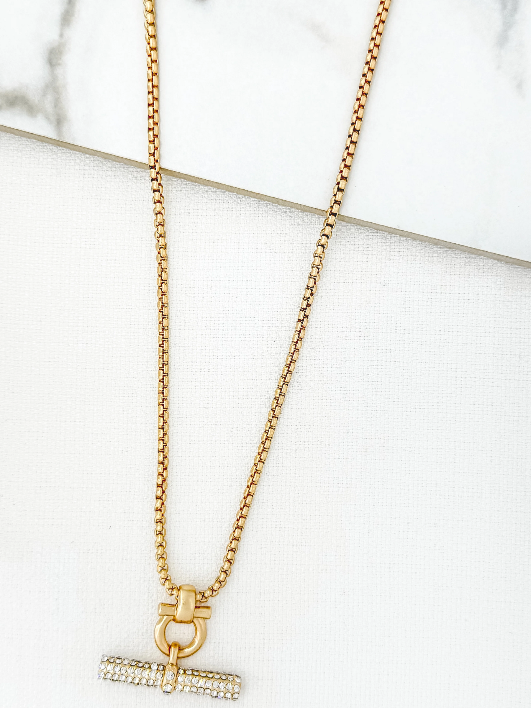 ENVY 4519 Gold Necklace featuring a gold-effect chain with a crystal-embellished bar pendant and toggle detail, a women’s statement necklace perfect for layering or evening wear.