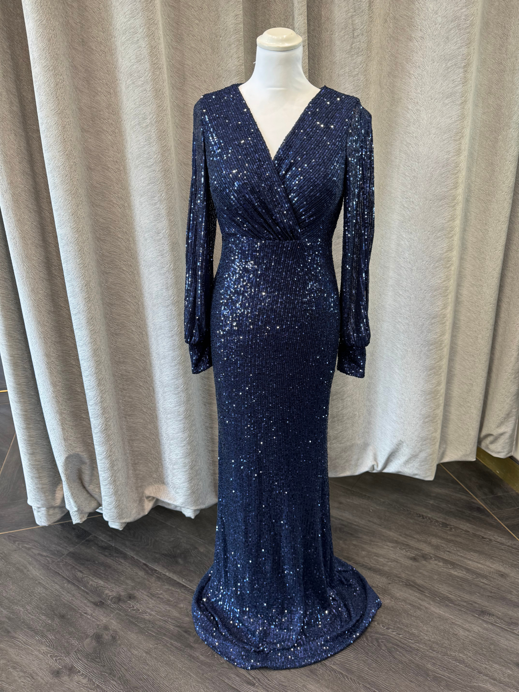 Frank Lyman 239808U Navy Sequin Dress – full-length evening gown with V-neckline, long sleeves, and flattering wrap-style fit. Elegant navy blue sequin occasion dress perfect for black-tie events and special occasions.